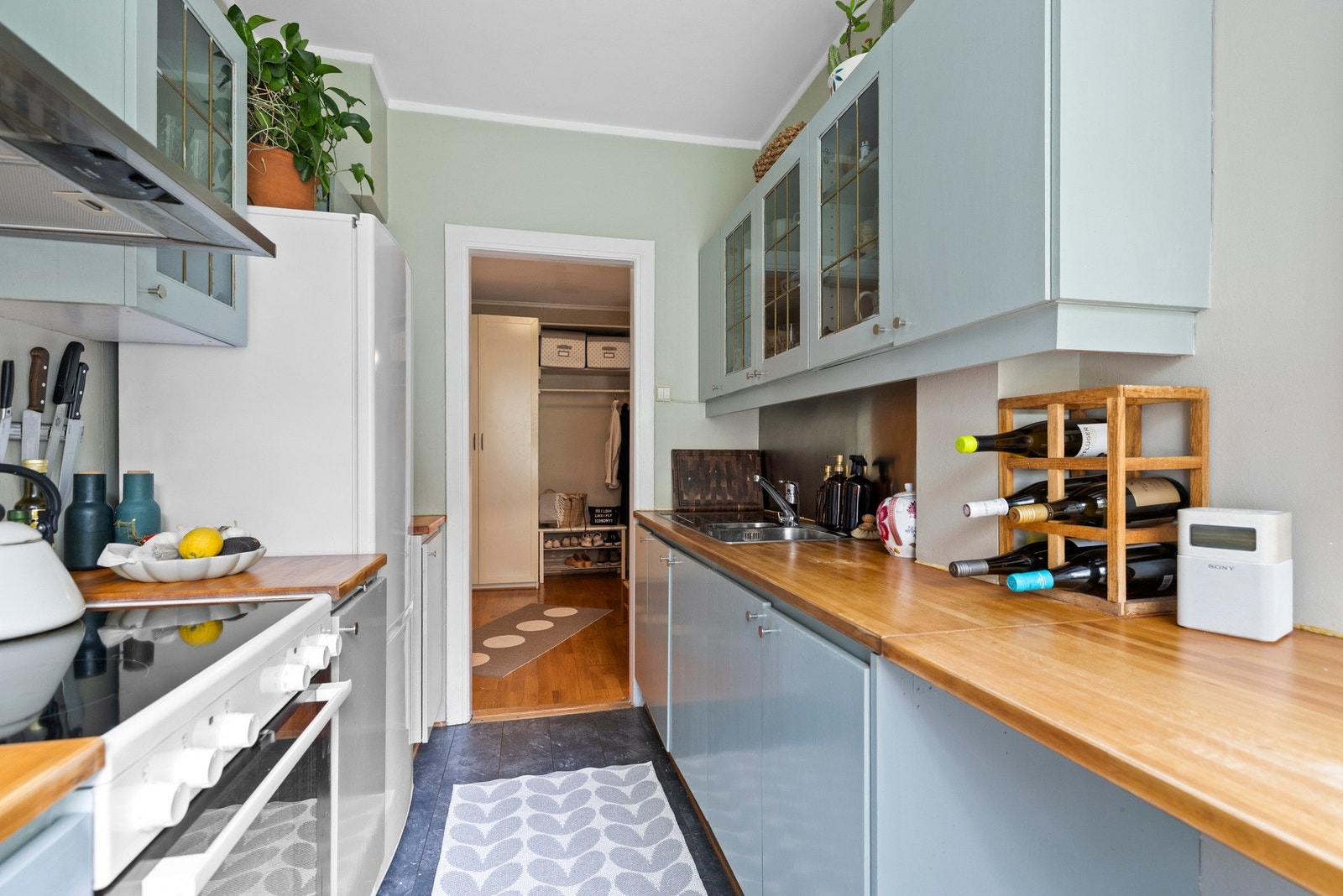 Kjøkkenet kombinerer praktiske løsninger med en behagelig fargepalett og rikelig med skap- og benkeplass Galleribilde