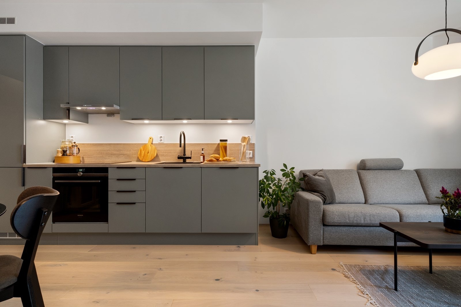 Stilrent kjøkken fra HTH. Kjøkkenfrontene er opgradert til en lekker grønnfarge med en elegant splash guard i samme utførelse som benkeplaten. Galleribilde