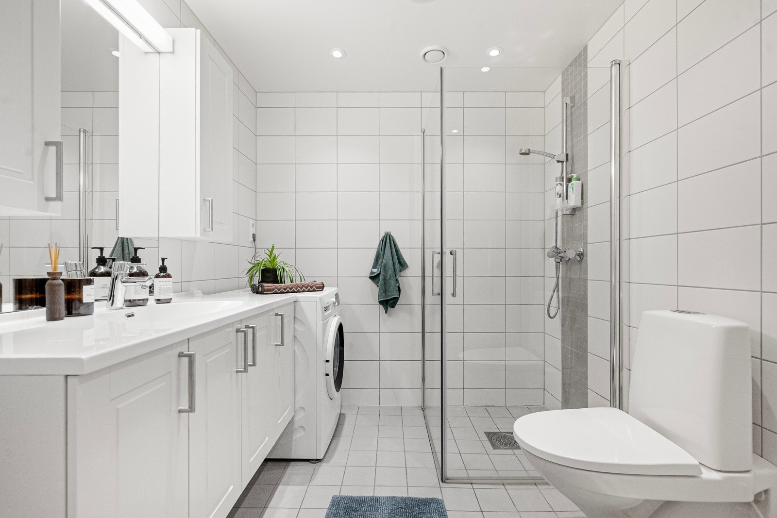 Badet er innredet med baderomsinnredning, estra høyskap, wc, dusj og opplegg for vaskemaskin. Galleribilde