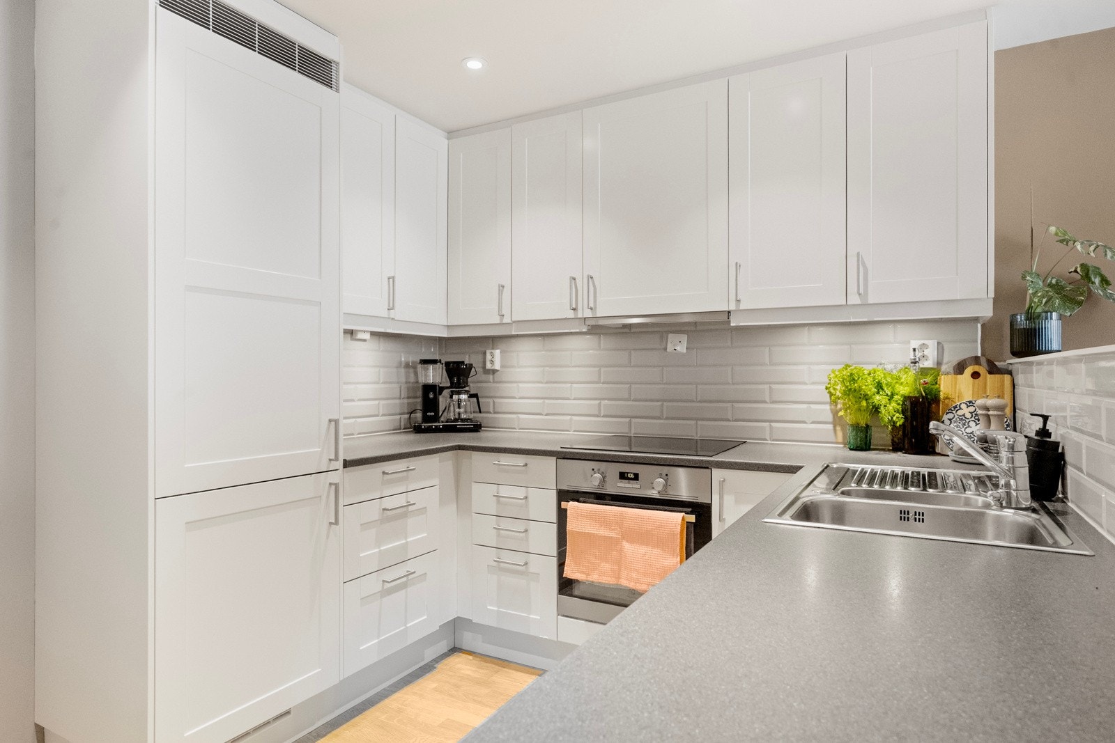 Lyst og pent kjøkken med integrerte hvitevarer. Galleribilde