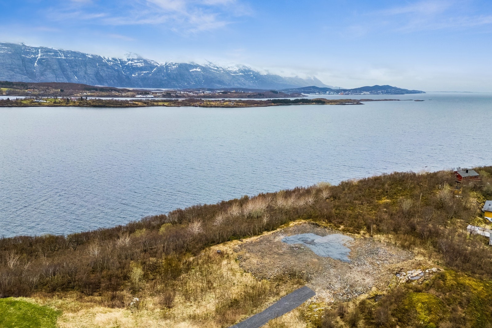 Ubebygd tomt på Reines i Leirfjord kommune med utsikt mot Ulvangsøya, Sandnessjøen, Skorpa m.m. Foto: EFKT. Galleribilde