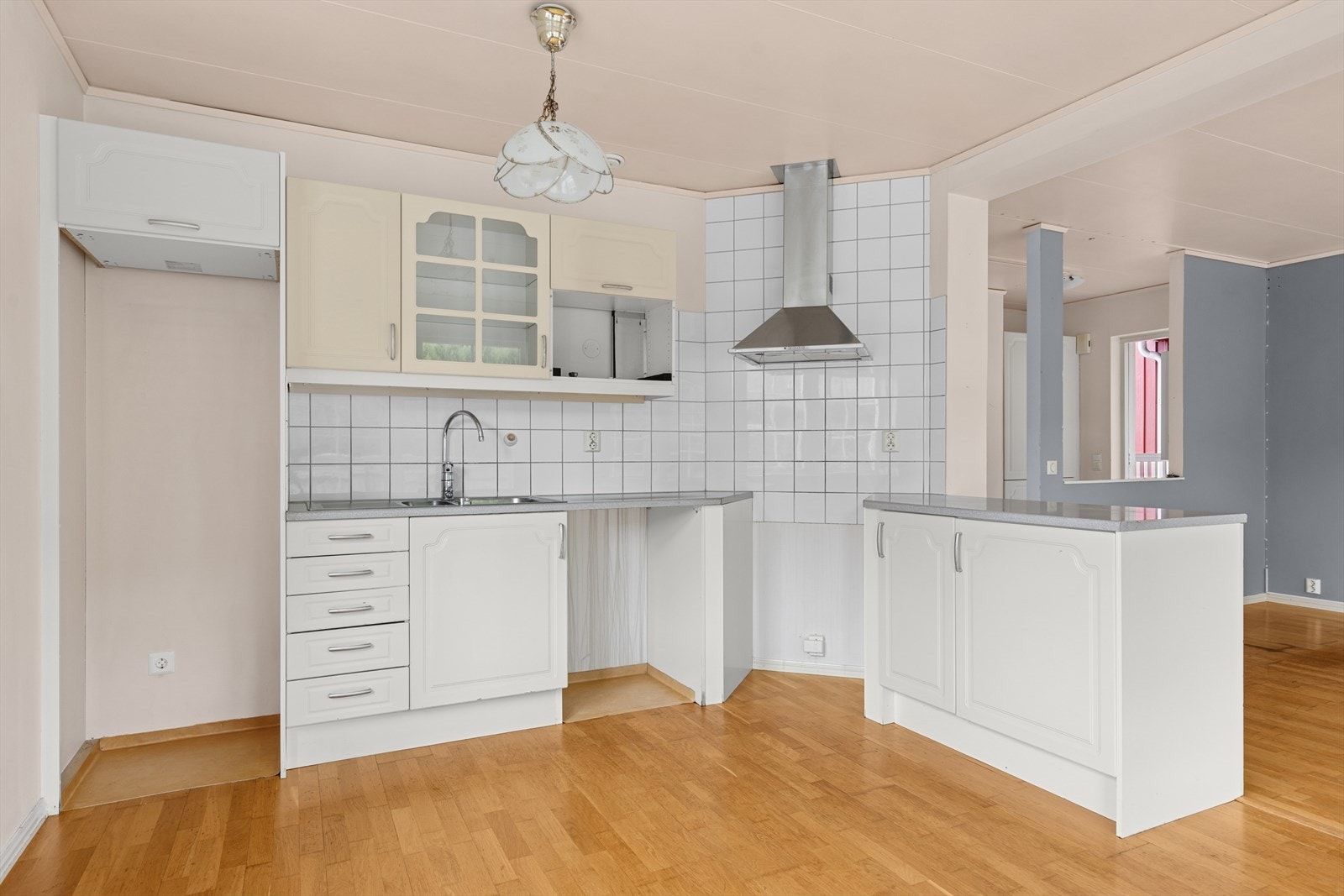 Innredningen er hvit med slette fronter og laminat benkeplate. Det er plass for komfyr og kjøleskap. Galleribilde