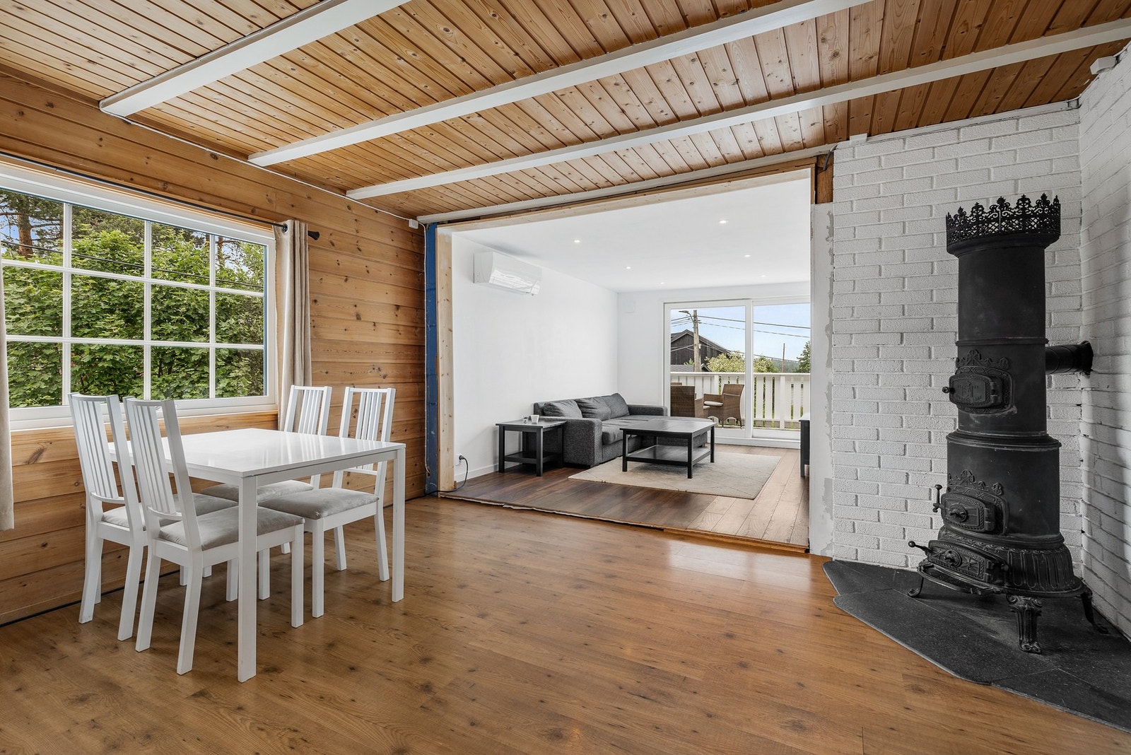 Det er åpen løsning mellom stue og kjøkken, og spisebordet får sin naturlige plassering ved vindu Galleribilde