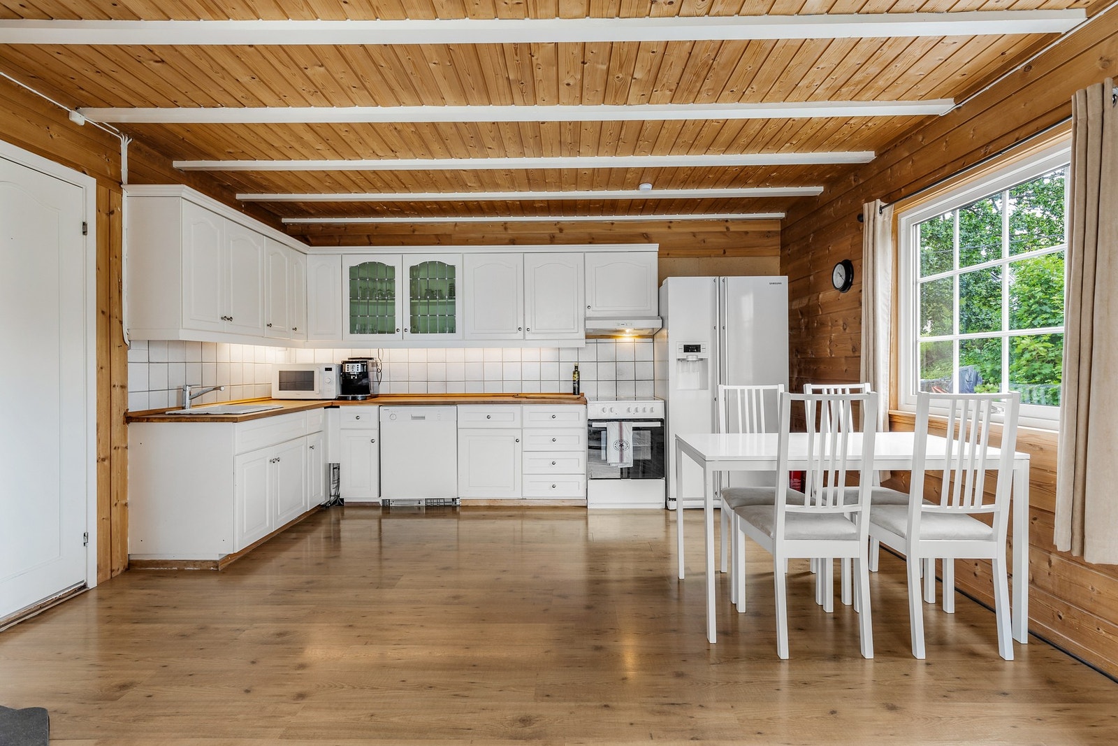 Kjøkkeninnredning med profilerte fronter og heltre benkeplate med en nedfelt stålvask med ettgreps-blandebatteri Galleribilde