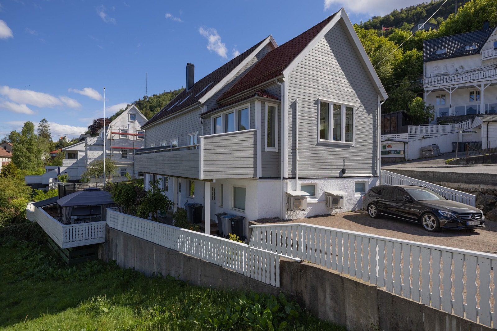 Det er parkeringsplass ved inngangsdør, og i tillegg parkering på andre siden av huset. Begge sider har elbillader. Galleribilde