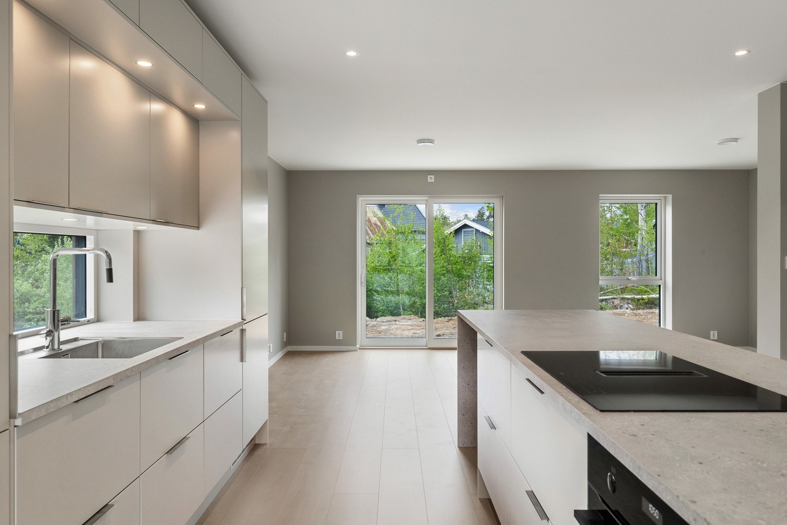 Innredningen er fra Norema og har moderne beige fronter som harmonerer elegant med veggfargen, kombinert med laminatbenkeplate, oppvaskkum og praktisk ettgreps blandebatteri med uttrekk. Galleribilde