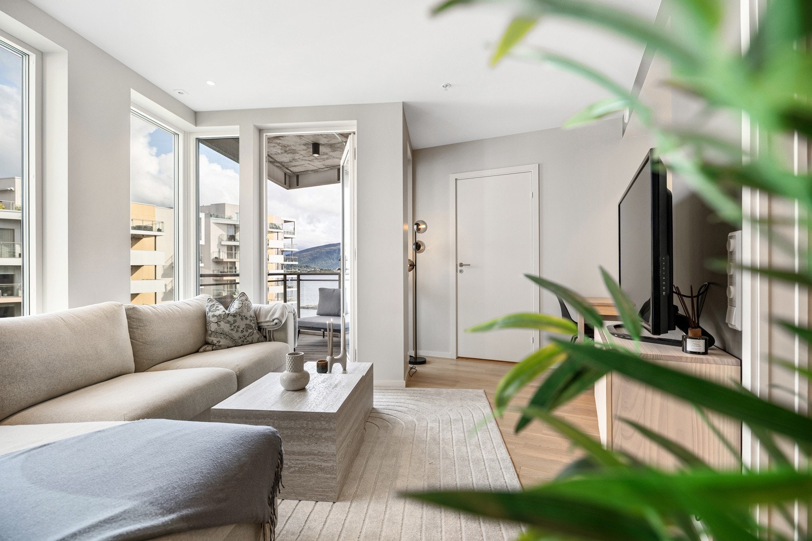 Her er det plass til sofa, TV med tilhørende møblement og et spisebord i overgangen til kjøkkenet. Galleribilde