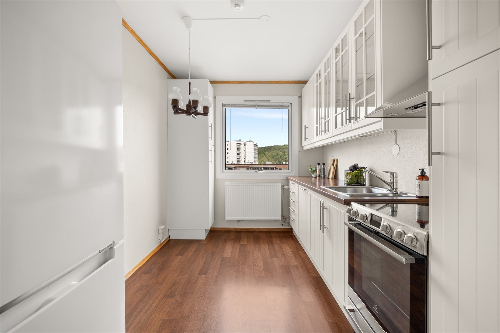 Kjøkkenet er utstyrt med hvitevarer som komfyr, kjøl/fryseskap og integrert oppvaskmaskin Galleribilde