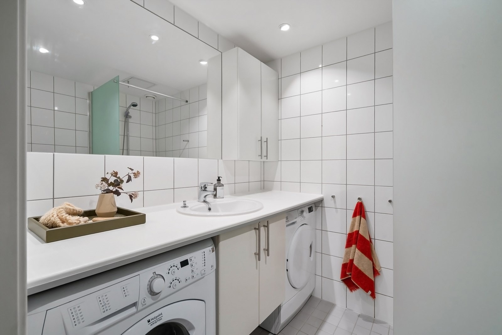 Delikat baderom med lyse flater. Det er flis på gulv og flis på vegg. Galleribilde