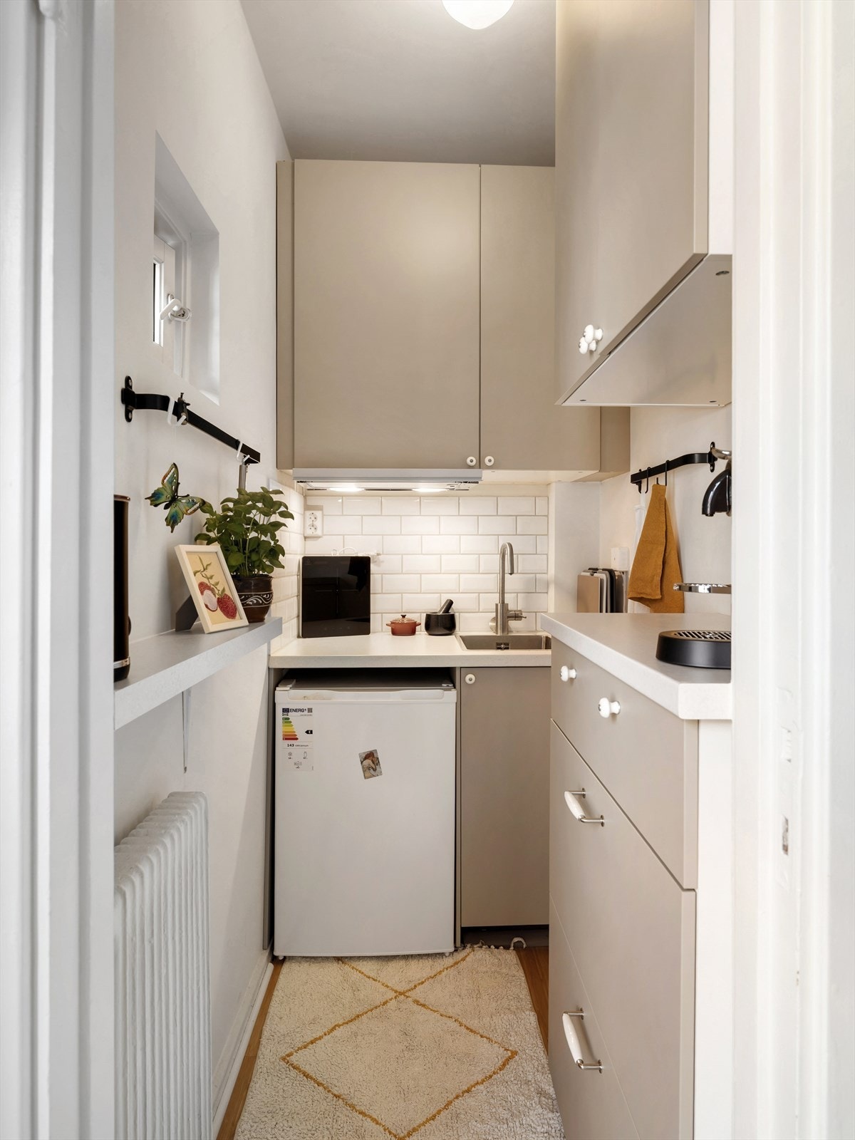 Glatte fronter fra 2024. Fliser mellom benk og overskap. Nedfelt oppvaskkum i børstet rustfritt stål med 1-greps blandebatteri. Galleribilde