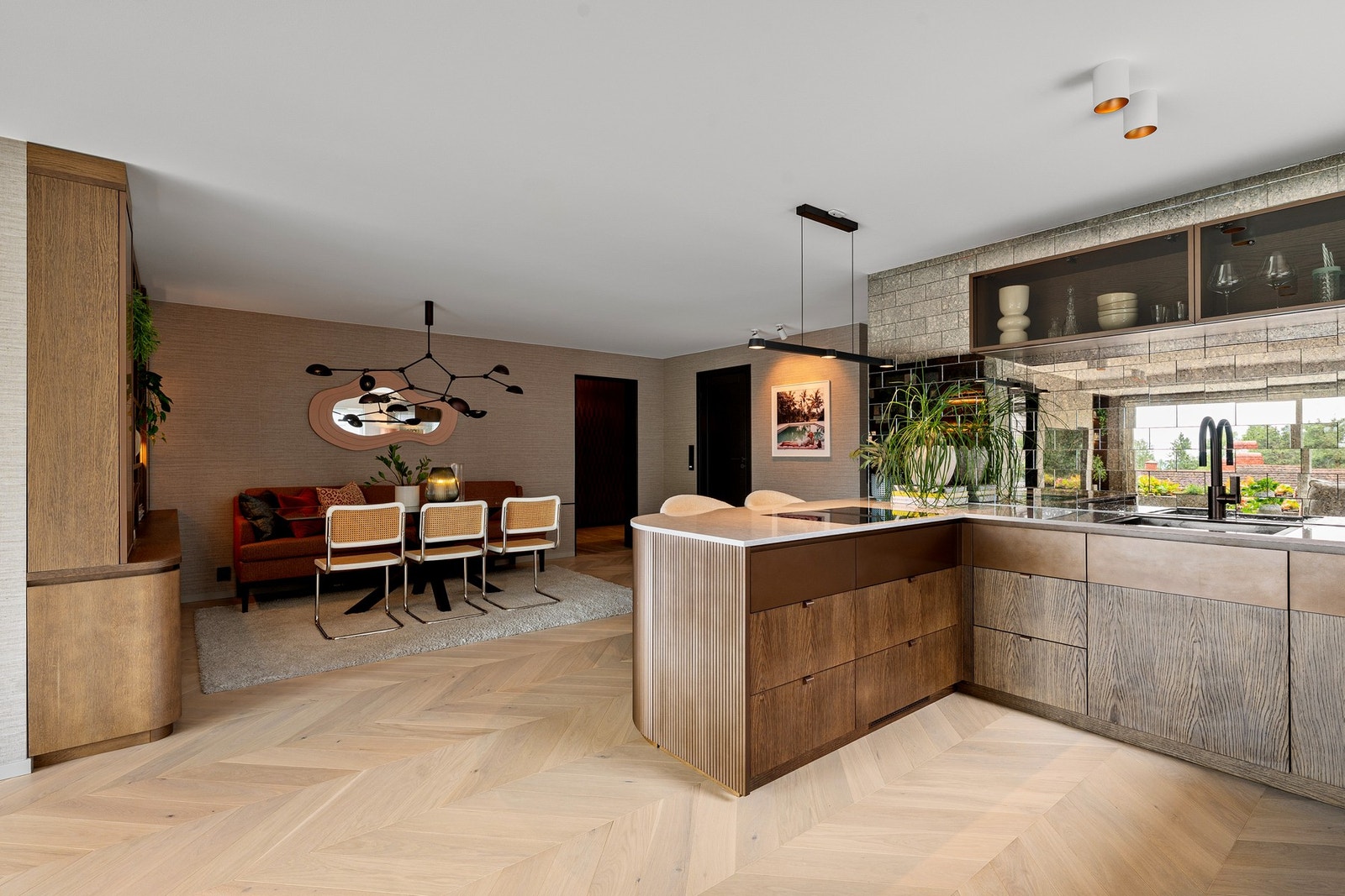 Unikt kjøkken med rillet bronsefront, Technistone benkeplate, spesialbygde overskap med bronseglass og integrert LED-lys. Galleribilde