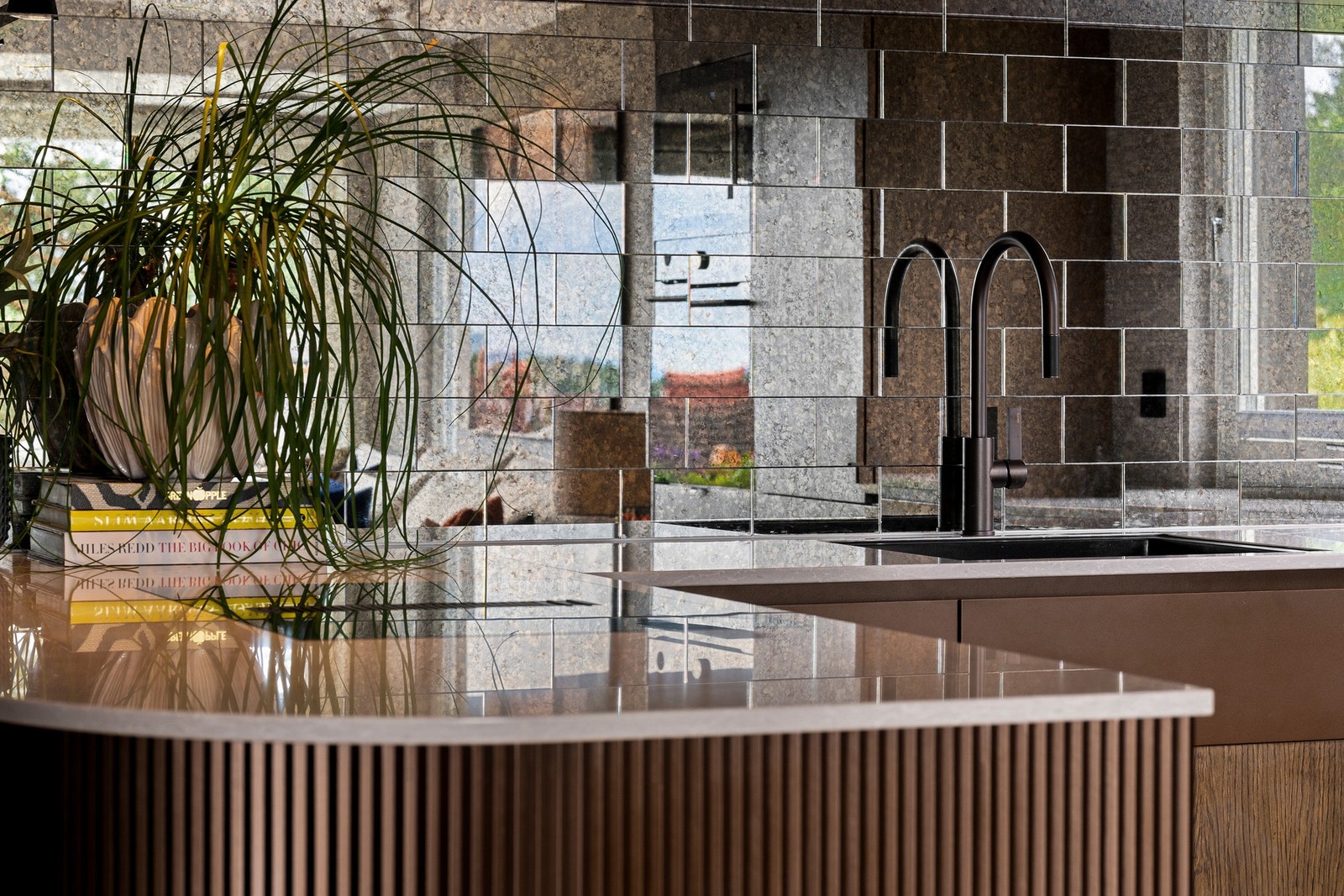 Eksklusive detaljer med planlimt koketopp og vask, Tapwell-armatur i bronse og Siemens-oppvaskmaskin med Zeolith tørkefunksjon og integrert vinskap. Galleribilde