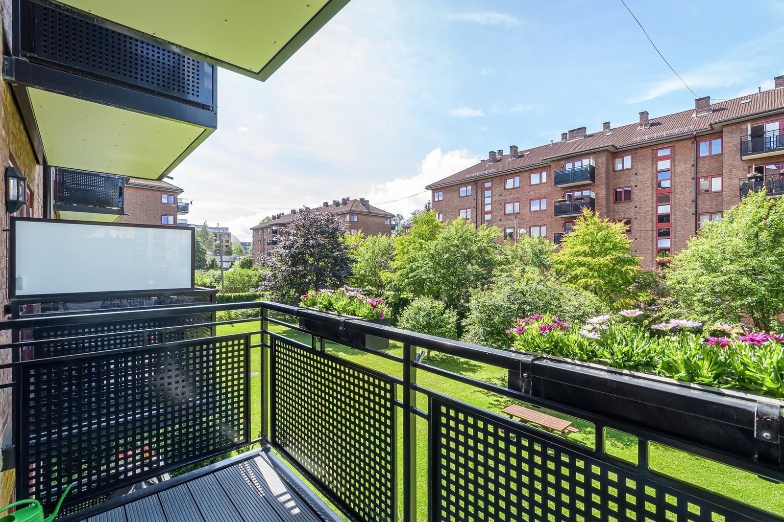 Utsyn fra balkongen mot frodige og velstelte fellesarealer. Galleribilde
