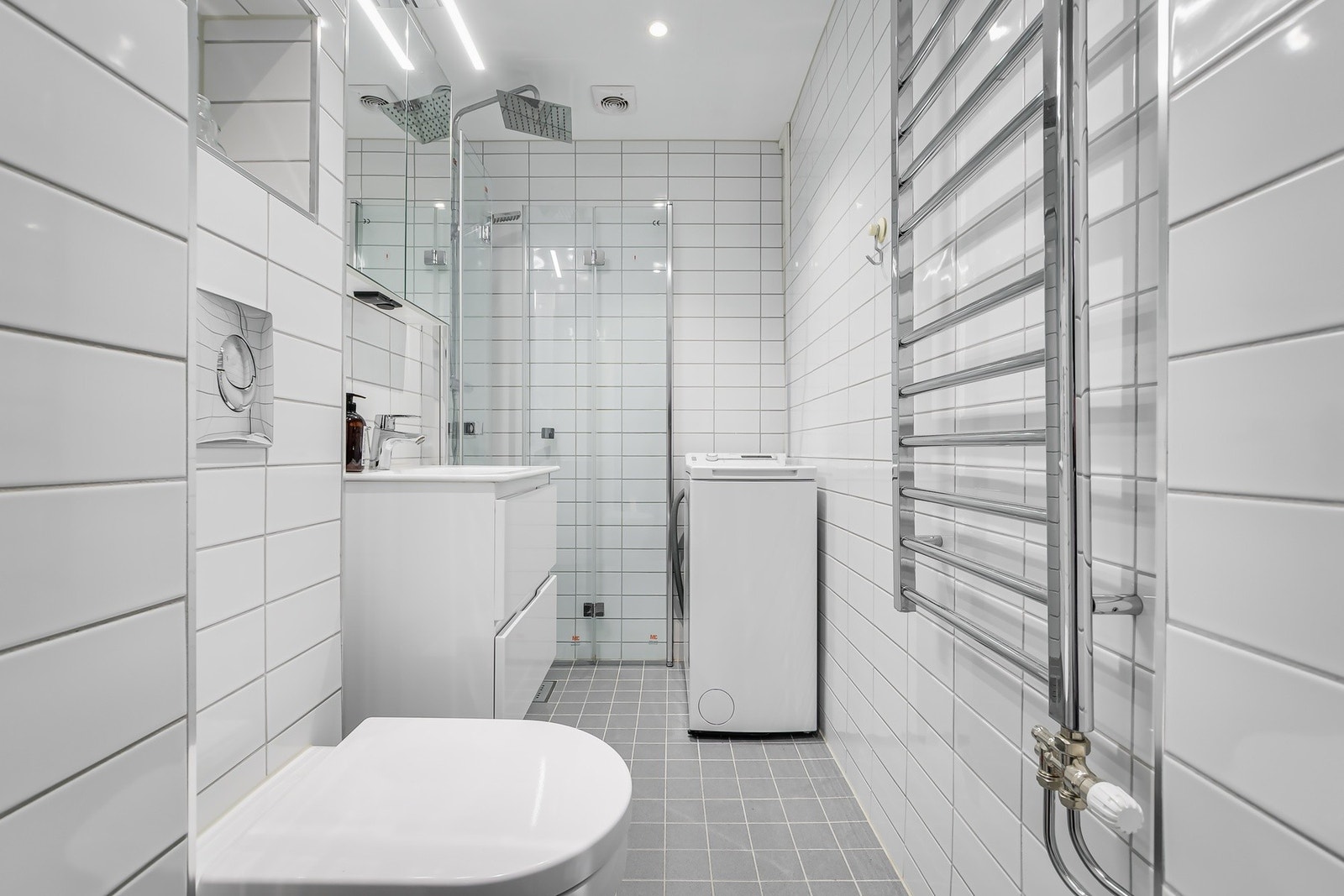 Praktisk opplegg for vaskemaskin og behagelig komfort med oppvarmet gulv og håndkletørker. Galleribilde