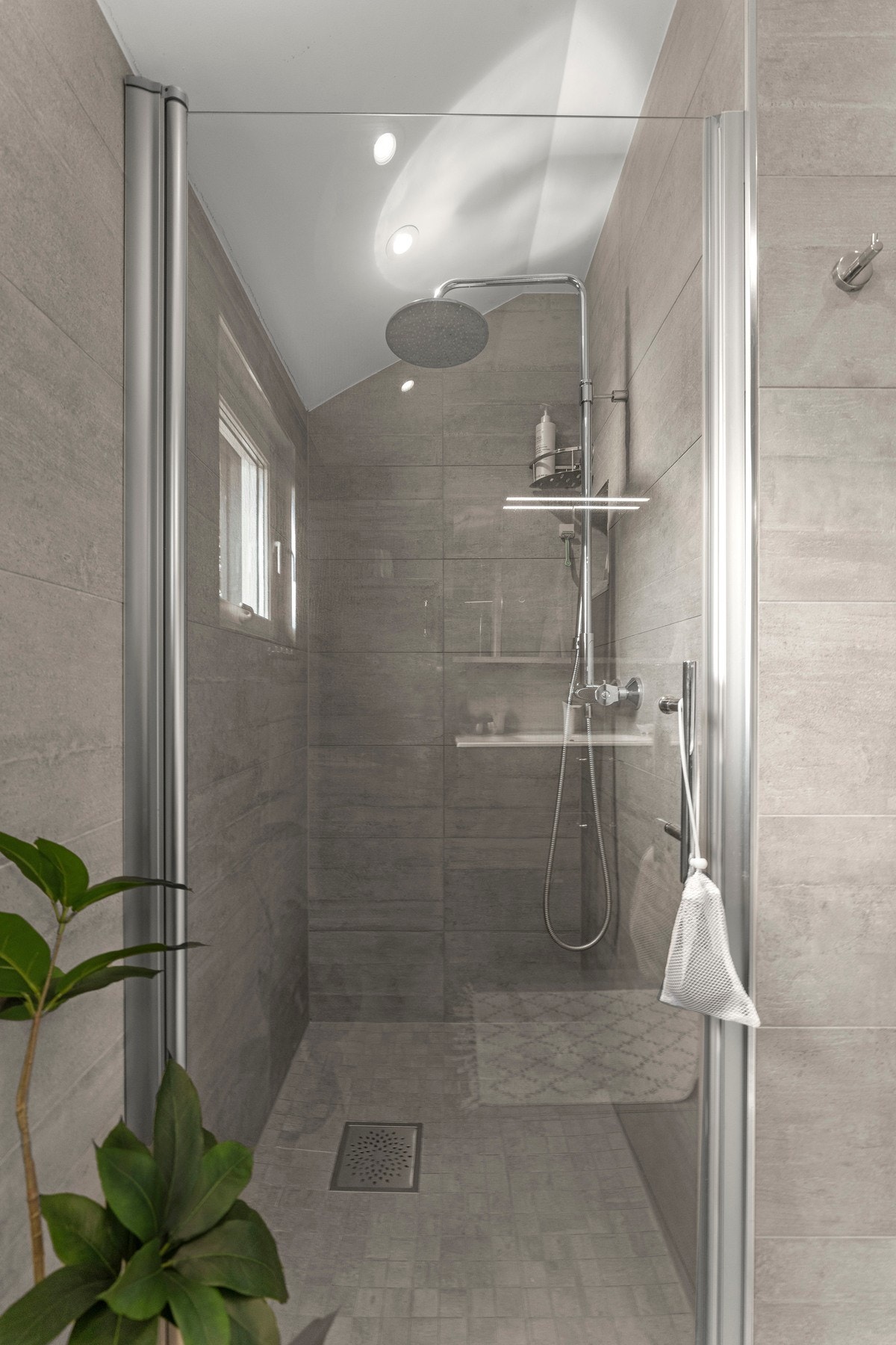 Badet er innredet med vegghengt toalett, elegant servant og dusjnisje med glassdører - en gjennomført kombinasjon av komfort og estetikk. Galleribilde