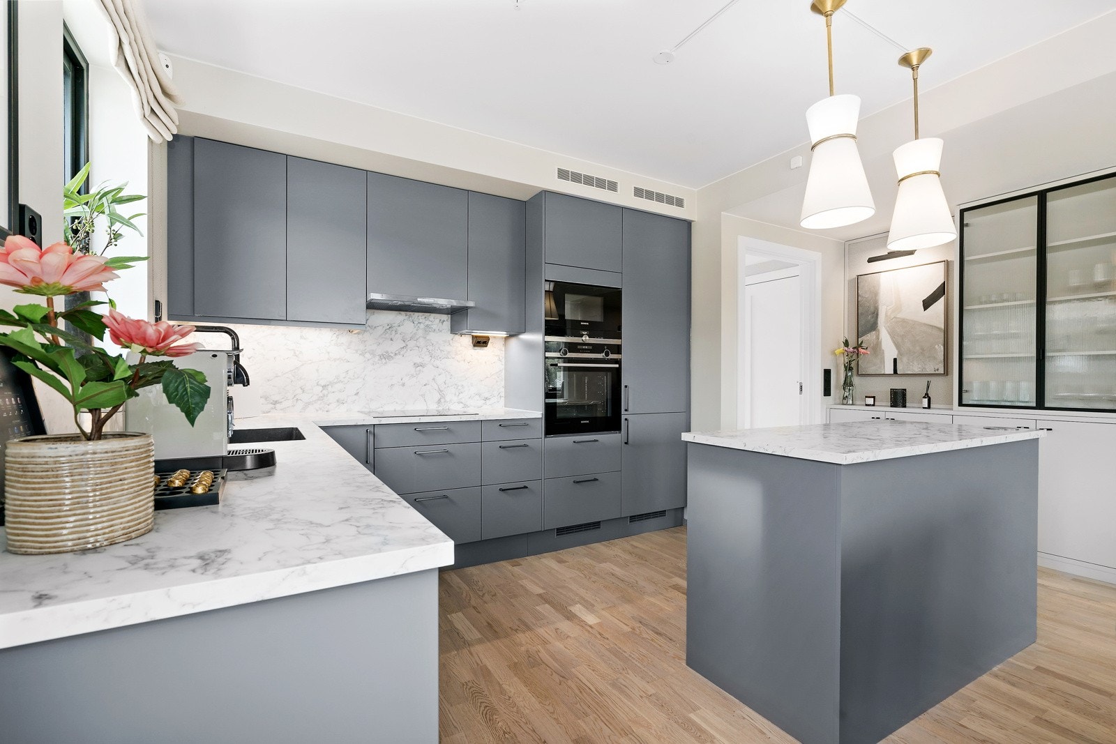 Kjøkkenet har fine detaljer som plassbygde skap mot gangen og benkeplater i marmorimitasjon Galleribilde