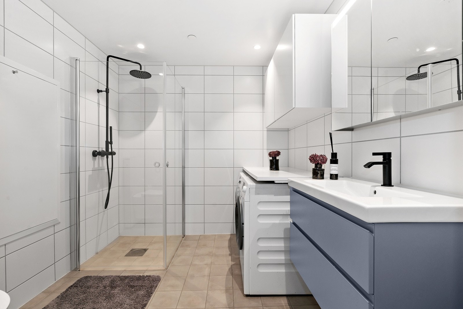 Badet er romslig og pent. Bred innredning med servant og skap over vaskemaskin og tørketrommel Galleribilde