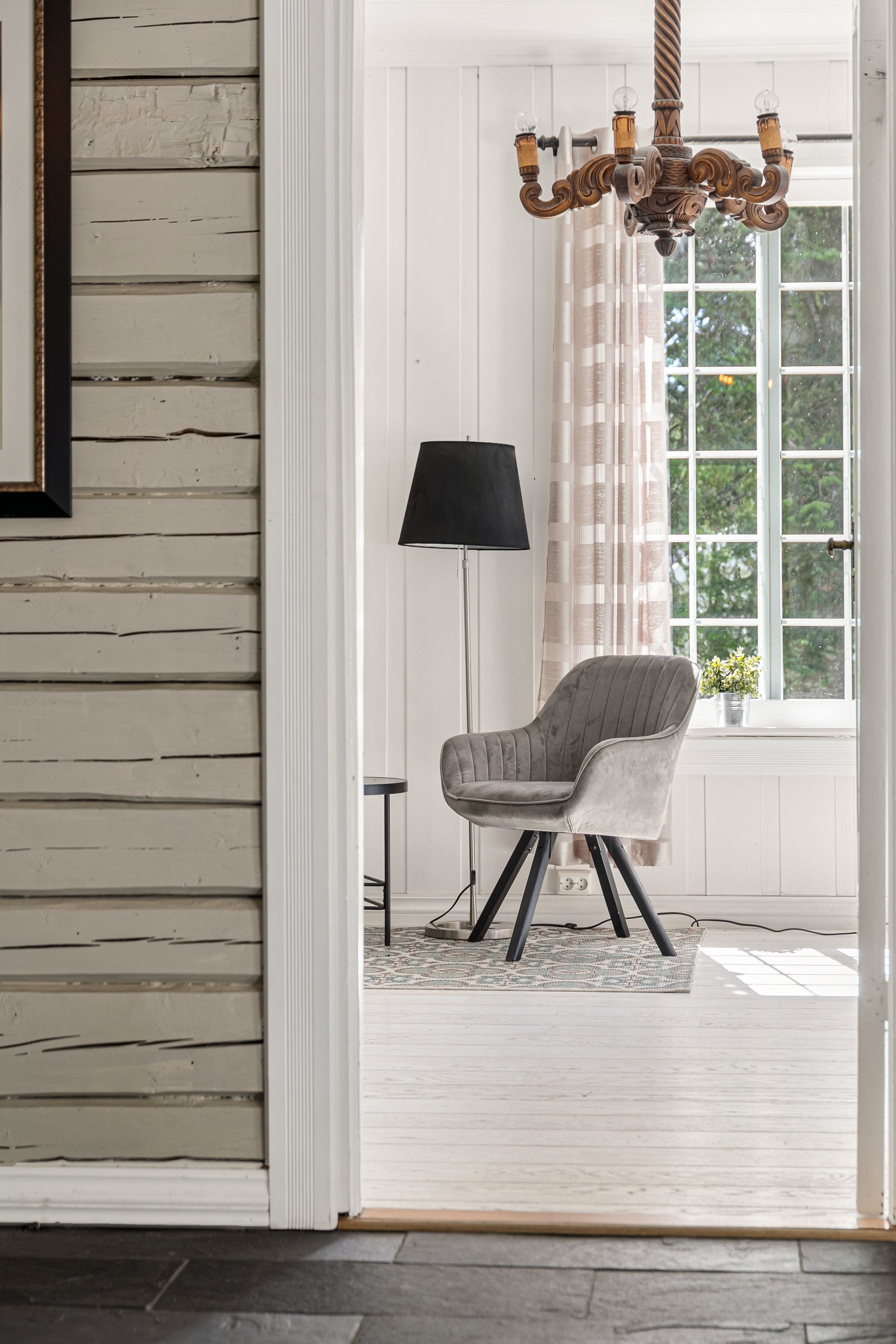 Detaljbilde - flotte laftede gråmalte malte innvendige vegger i gang, i fin kontrast til lyse panelte vegger i stue. Galleribilde