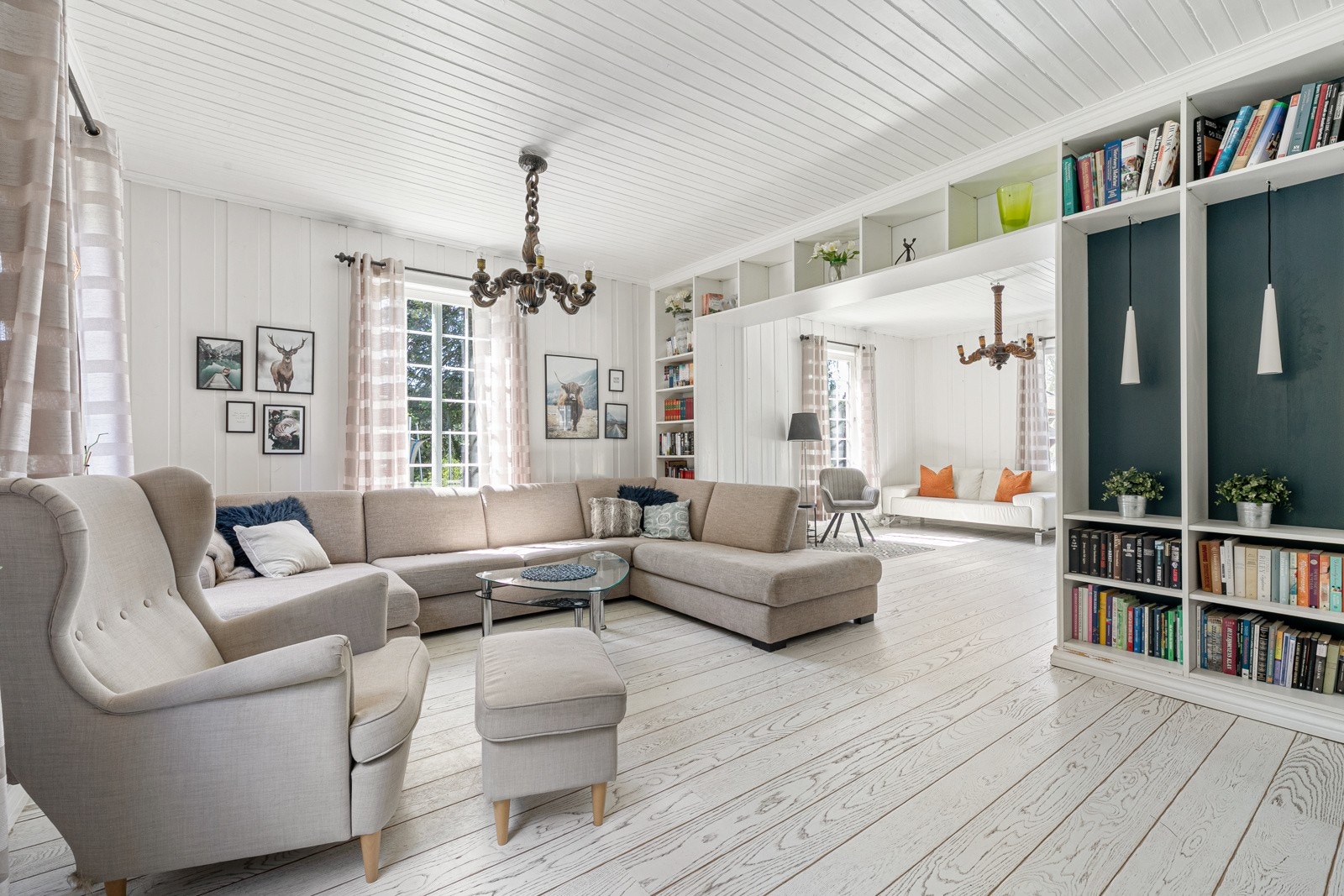 Innbydende og romslig hovedstue med god plass til sofamøblement. Integrerte bokhyller tilfører rommet et hjemmekoselig preg. Galleribilde