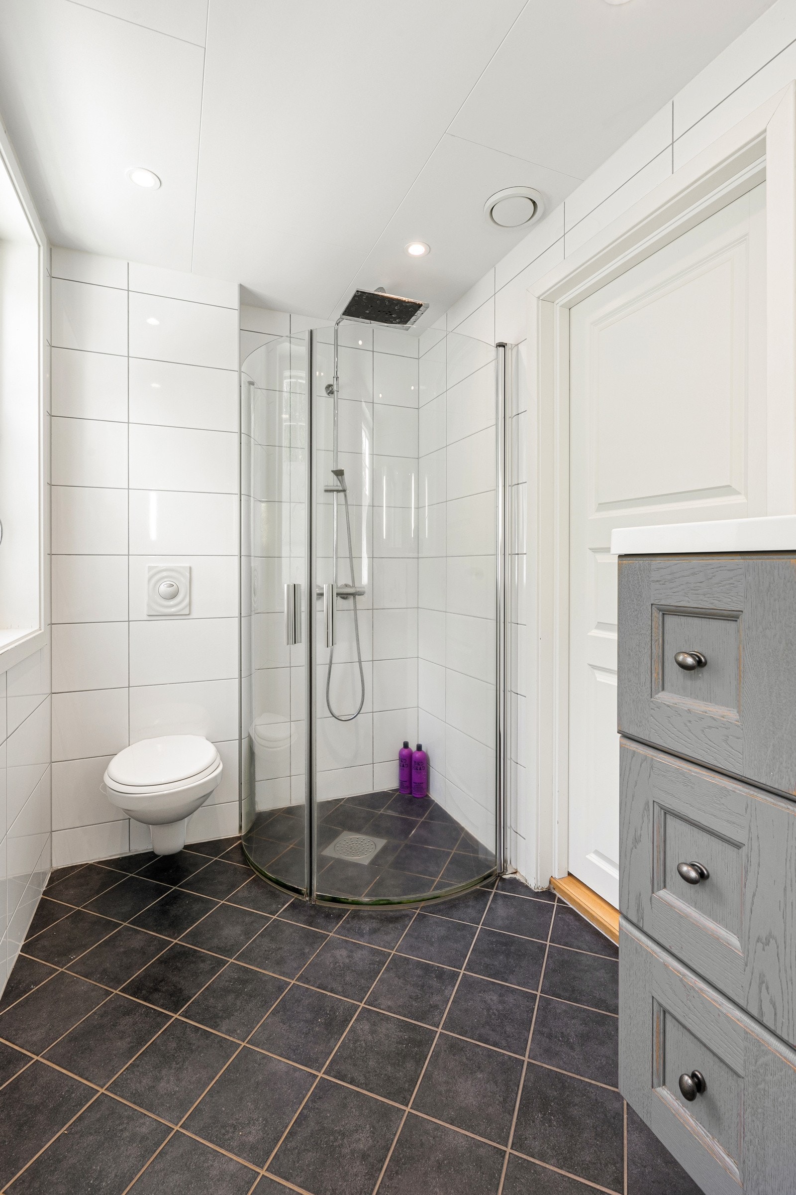 Badet har dusjsone med innfellbare dusører, vegghengt toalett samt servant med underskap Galleribilde