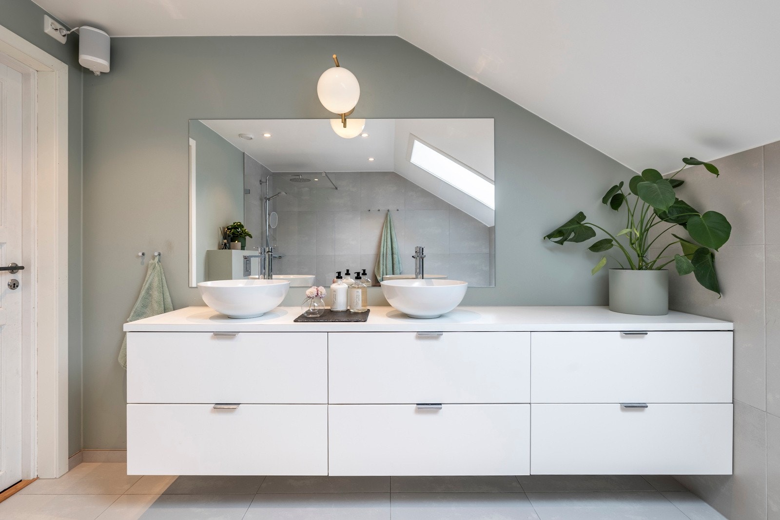 Badet er stilfullt innredet med flislagte gulv, og en kombinasjon av malte flater og fliser på veggene. Galleribilde