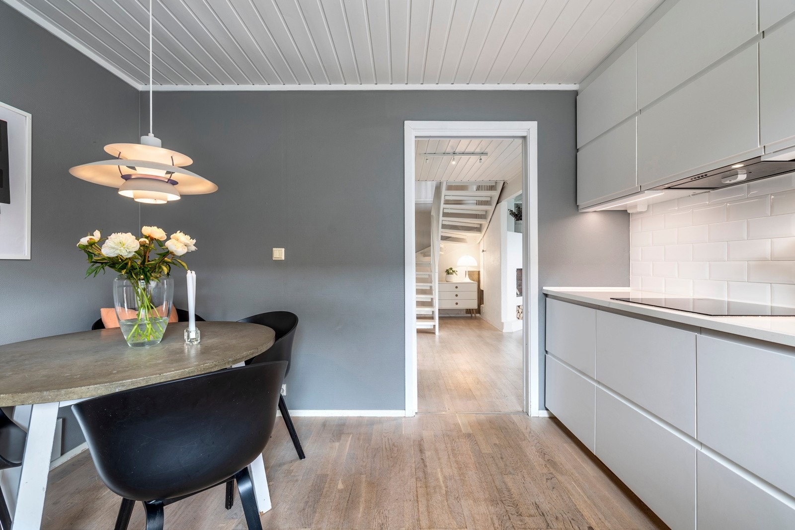 Det er praktisk belysning under overskapene, og det er fliser på vegg mellom overskap og kjøkkenbenk som gir et stilfullt preg. Galleribilde