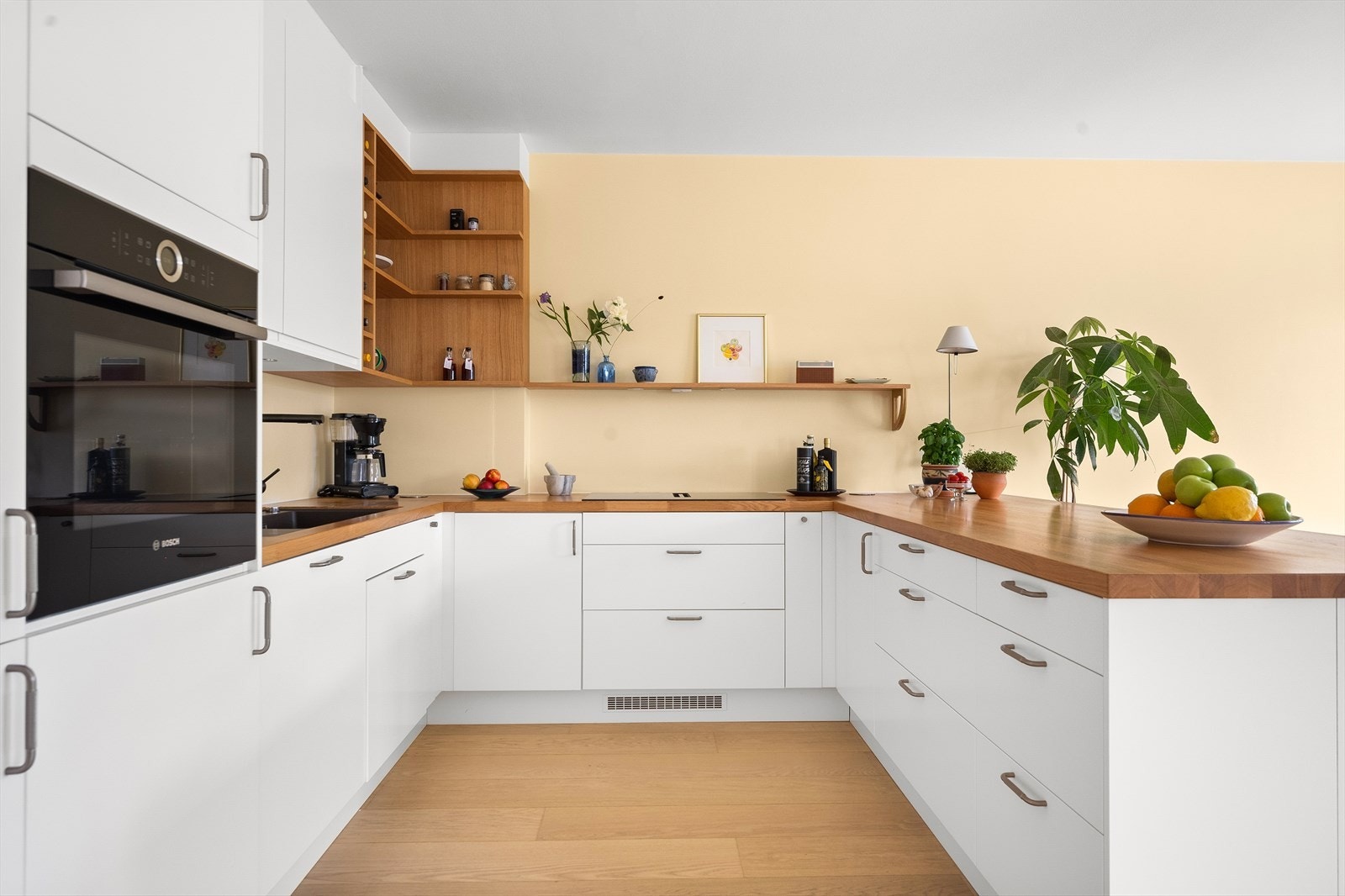 Kjøkkenet har integrerte hvitevarer som induksjon koketopp med integrert avtrekk, stekeovn i høyskap, kjøleskap/fryser og oppvaskmaskin Galleribilde