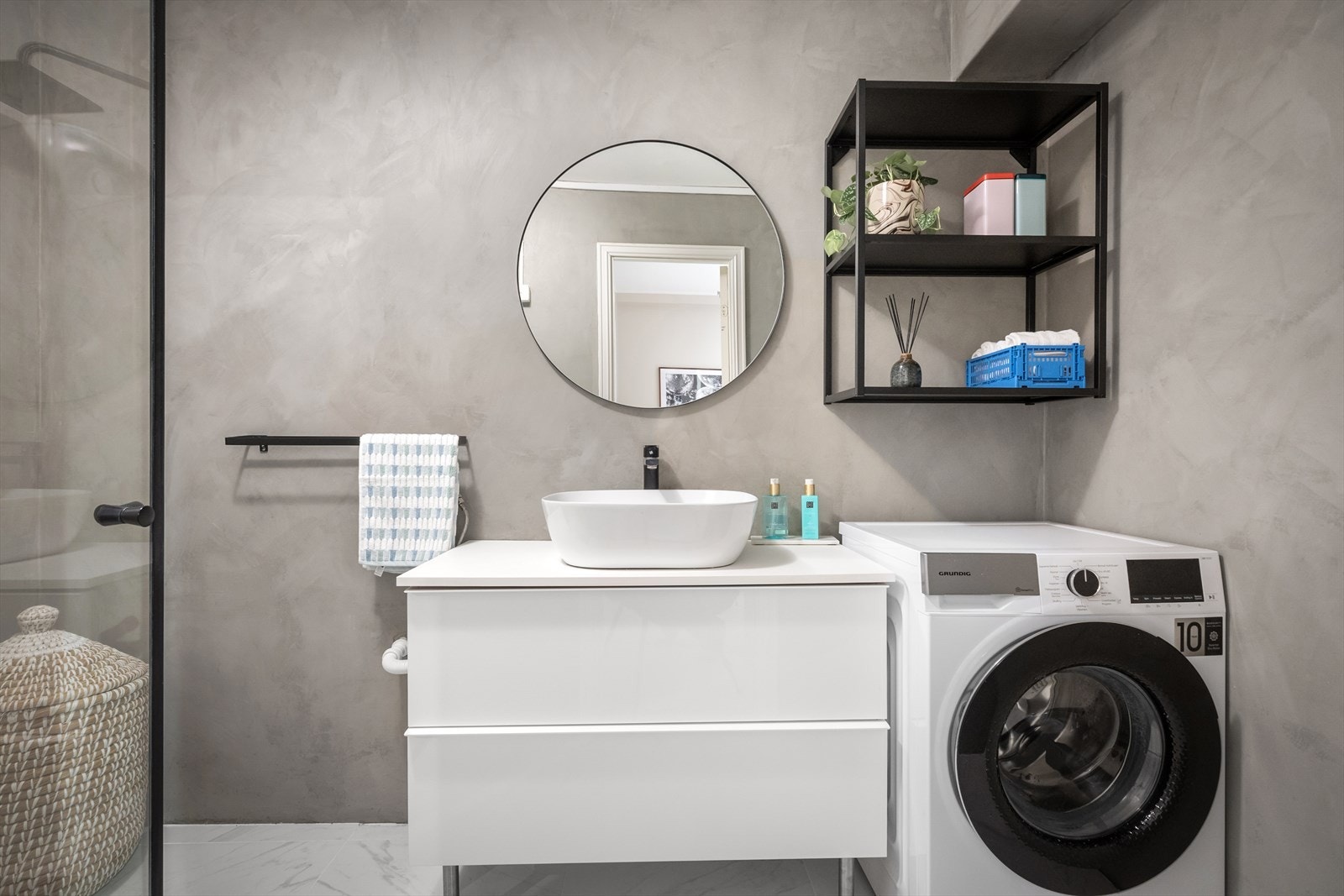 Badet måler 4,5 m², med stilren vask med praktiske skuffer, samt god plass til vaskemaskin. Galleribilde