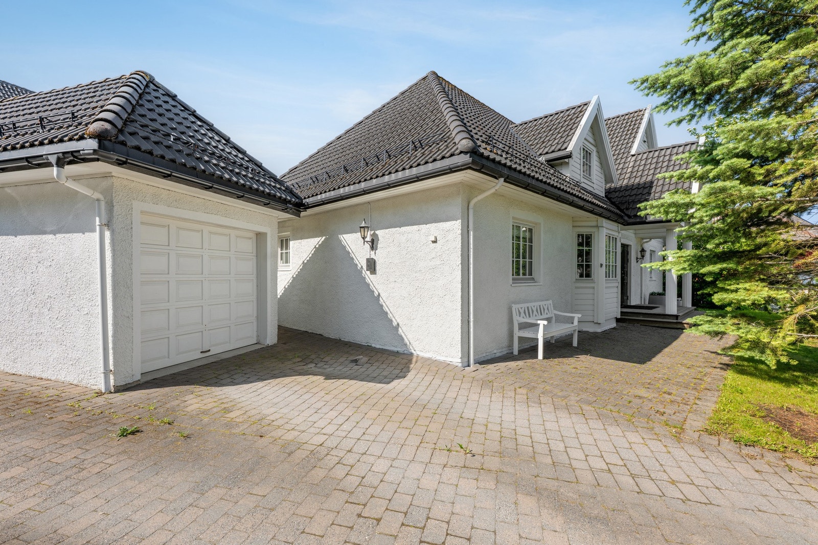 Parkering i garasje og på brosteinsbelagt parkeringsareal. Dersom man fjerner granbusk er det mulig å etablere mere parkering. Galleribilde