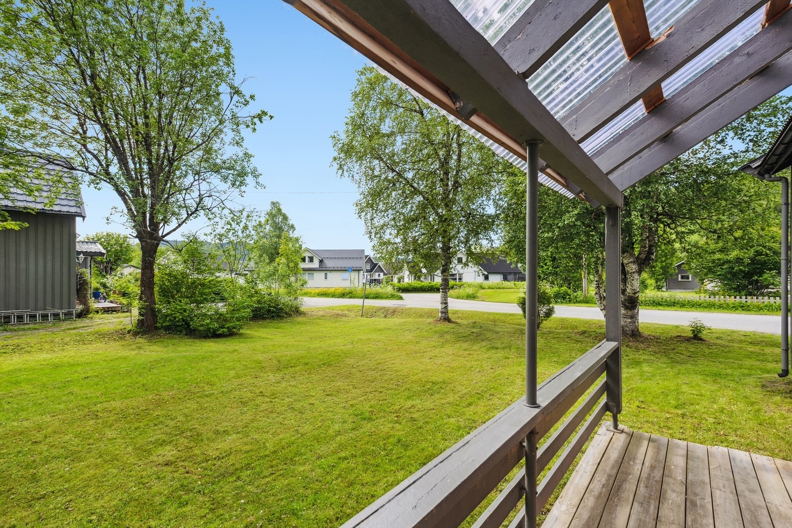 Tomten er flat og har en eldre plen med busker som gir et naturlig preg. Galleribilde