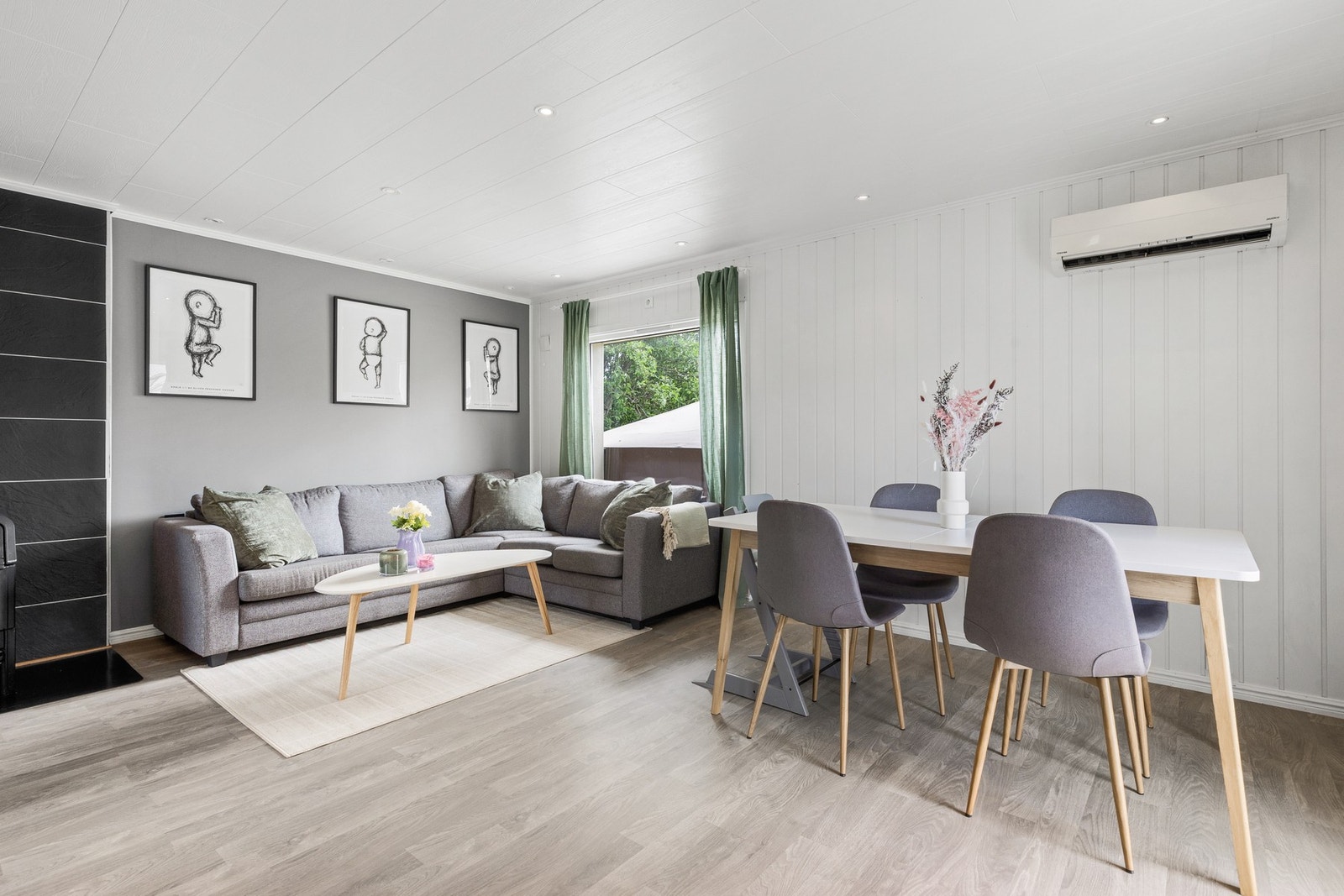 En romslig stue med god plass til sofagruppe og spisebord med tilhørende møblement Galleribilde