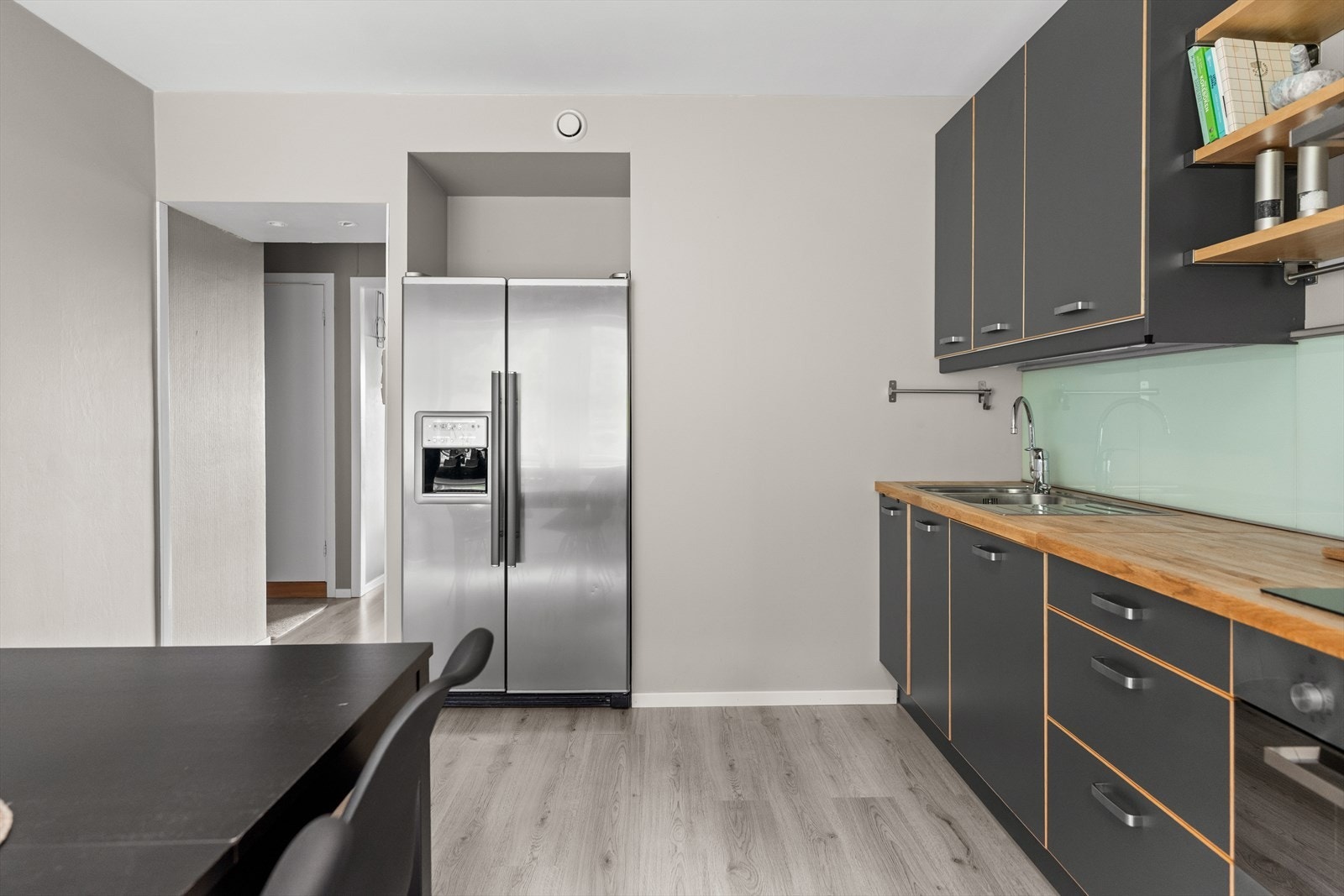 Det mørke kjøkkenet står i fin kontrast til den ellers lyse veggen. Galleribilde