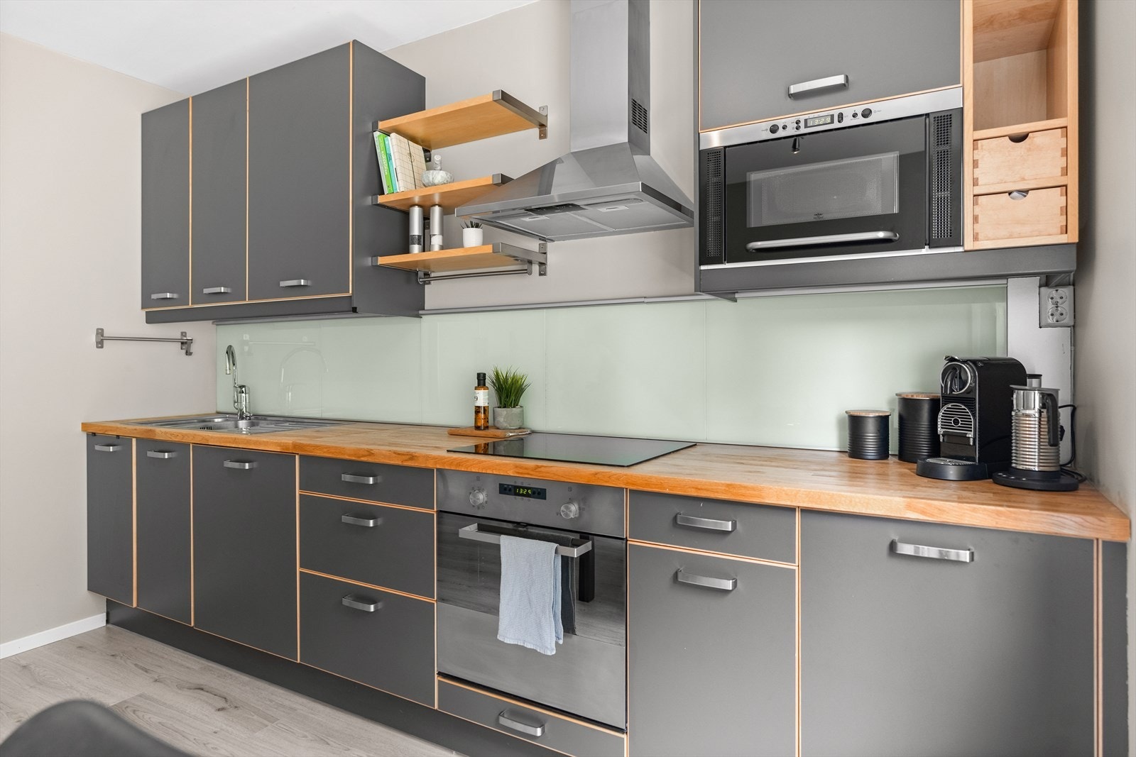 Kjøkkenet er stilrent og tidløst med mye skap, skuffer og benkeplass, i tillegg til integrerte hvitevarer. Galleribilde