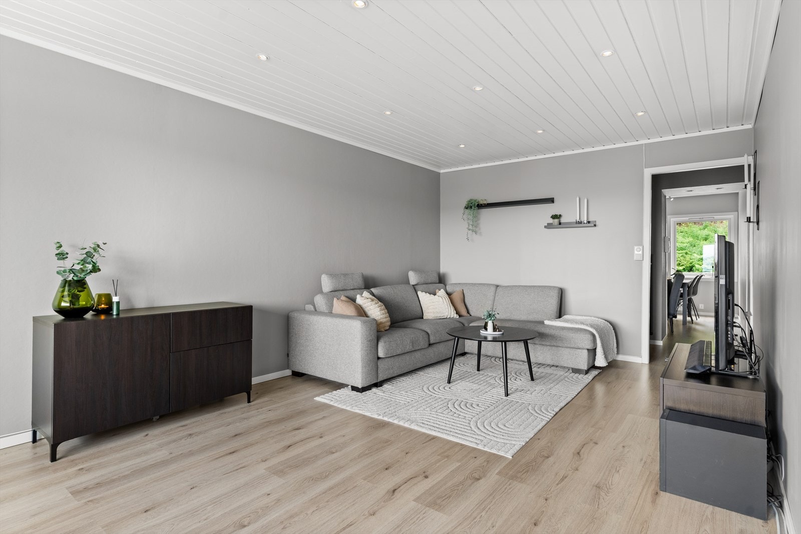 Leilighetens stue er romslig og lys, malt i en elegant, lys gråfarge. Galleribilde