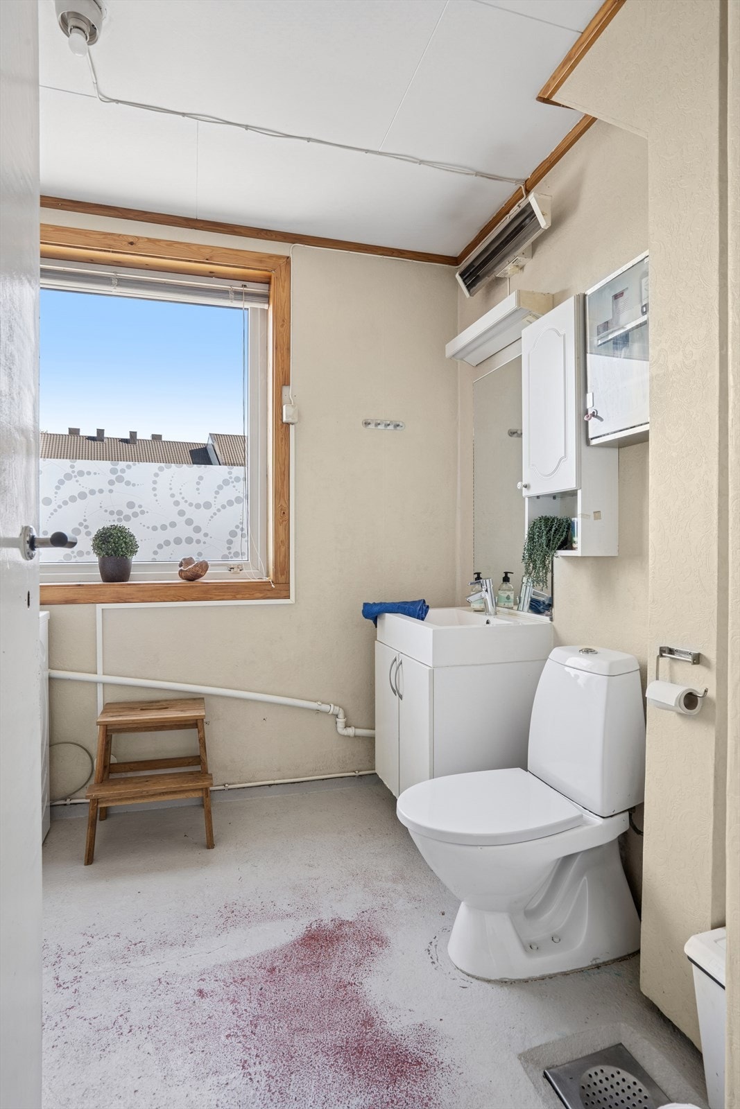 Badet er av eldre dato og er innredet med betonggulv og tapetserte vegger. Badet er ellers utstyrt med dusjkabinett, toalett og servant med skap under. I tillegg har man opplegg for vaskemaskin og varmtvannsbereder plassert på badet. Galleribilde