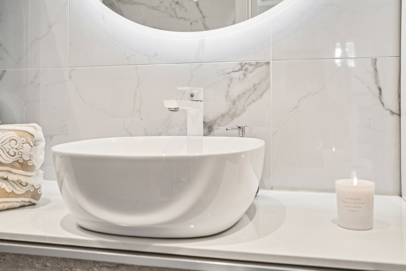 Baderomsinnredningen har glatte fronter, oppbevaring i skuffeseksjon og speil med integrert belysning. Galleribilde