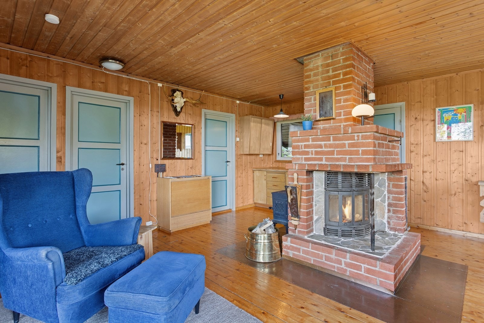 En vedovn og en peis med innsats er begge sentralt plassert i rommet og gir ekstra varme og hygge på kalde dager. Peisinnsatsen ble montert i 2024. Galleribilde