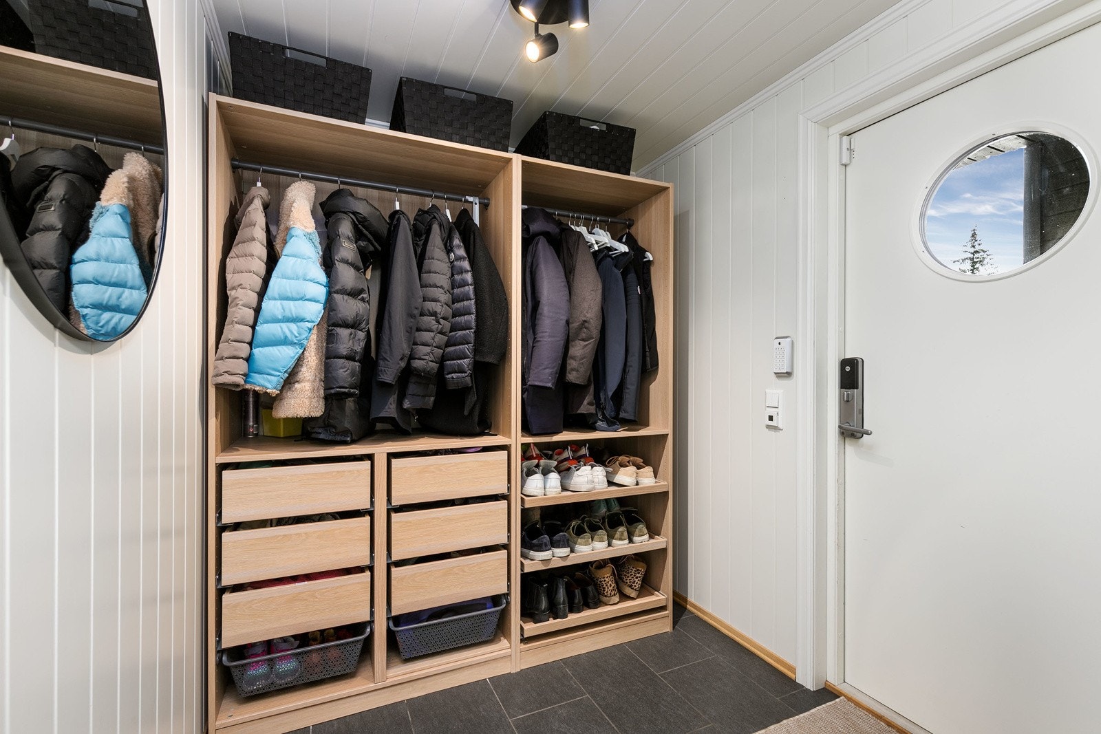 Lys og innbydende entre med delikate storformatfliser på gulv med gulvvarme og lysmalt smartpanel på veggflater, som gir et godt førsteinntrykk av boligen. Det er satt inn en åpen garderobeløsning i eik, perfekt til oppbevaring av yttertøy og sko. Galleribilde