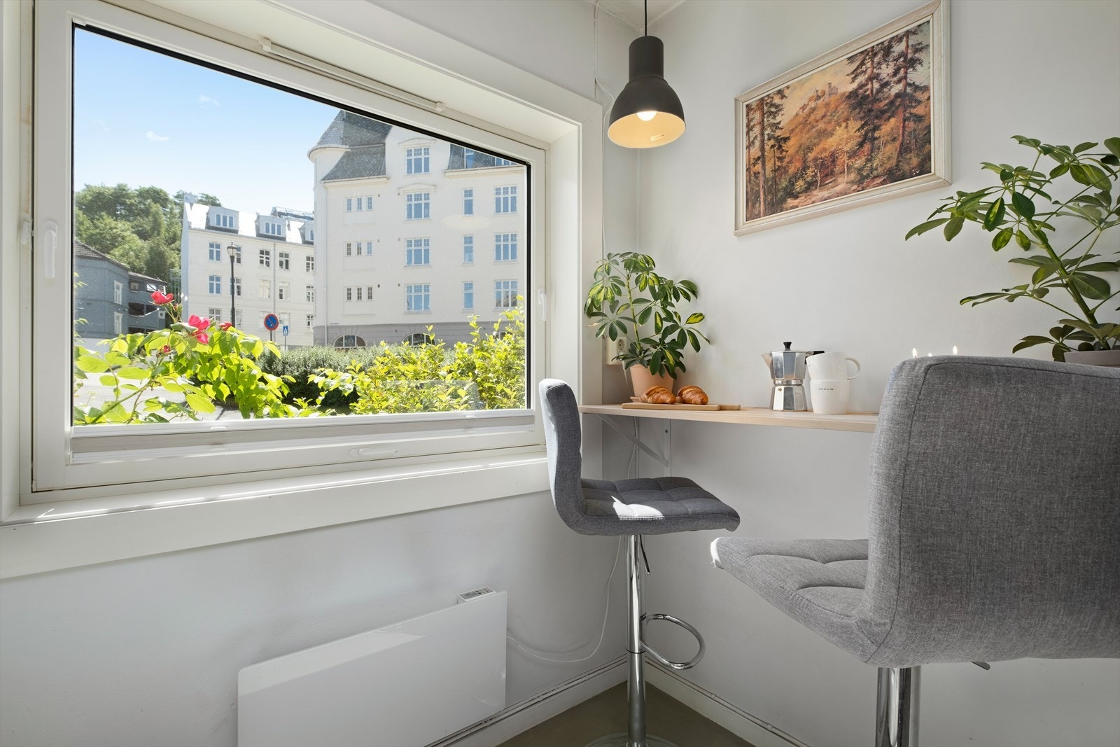 Kjøkkenet har en praktisk spiseseksjonsløsning med barstoler ved vinduet. Her får du fint med naturlig lysinnslipp, som bidrar til å lyse opp leiligheten og skaper en god atmosfære. Galleribilde