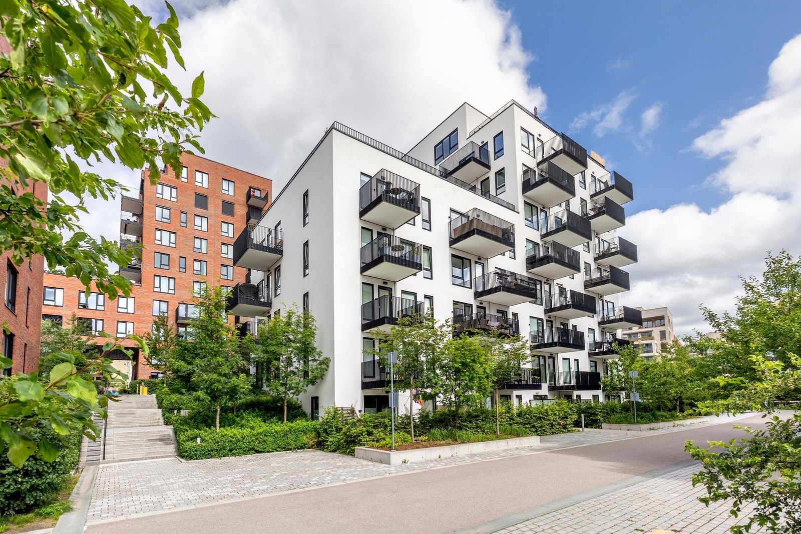 Pent opparbeidede fellesarealer med internstier, frodige plenområder og variert beplantning som skaper et innbydende og grønt bomiljø. Galleribilde