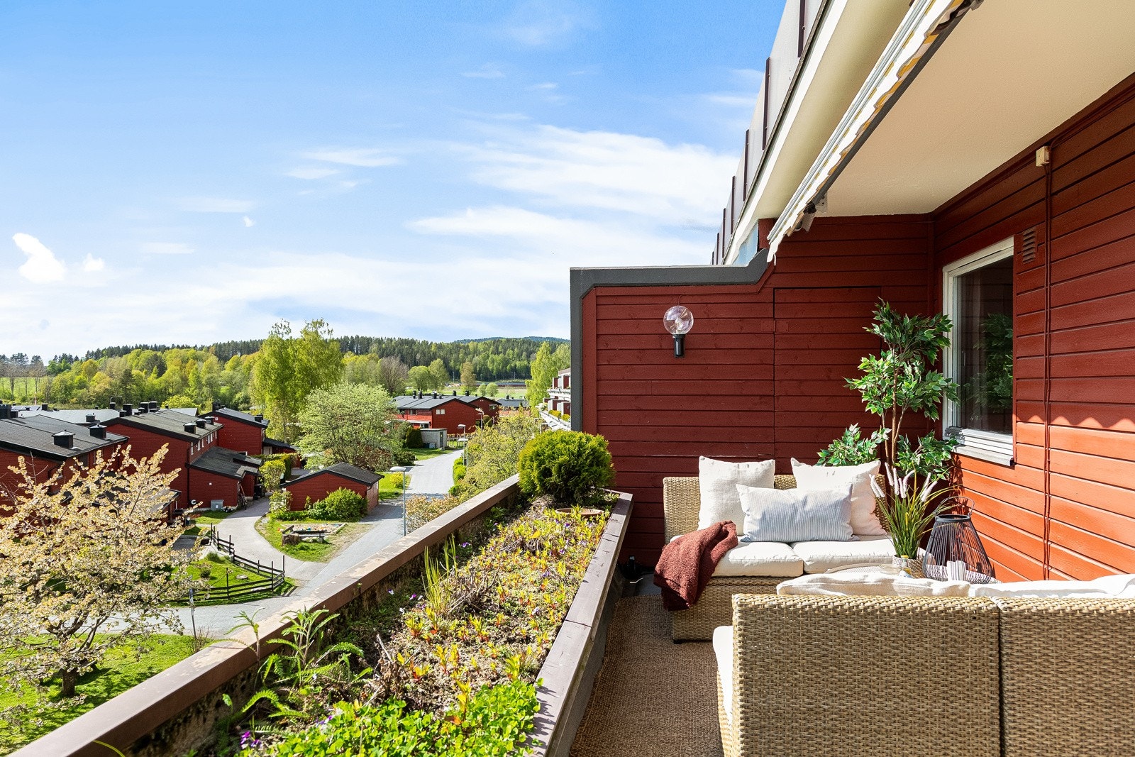 Terrasse med blomstertrau i front, skjermende levegger på siden og markise i overbygget. Galleribilde