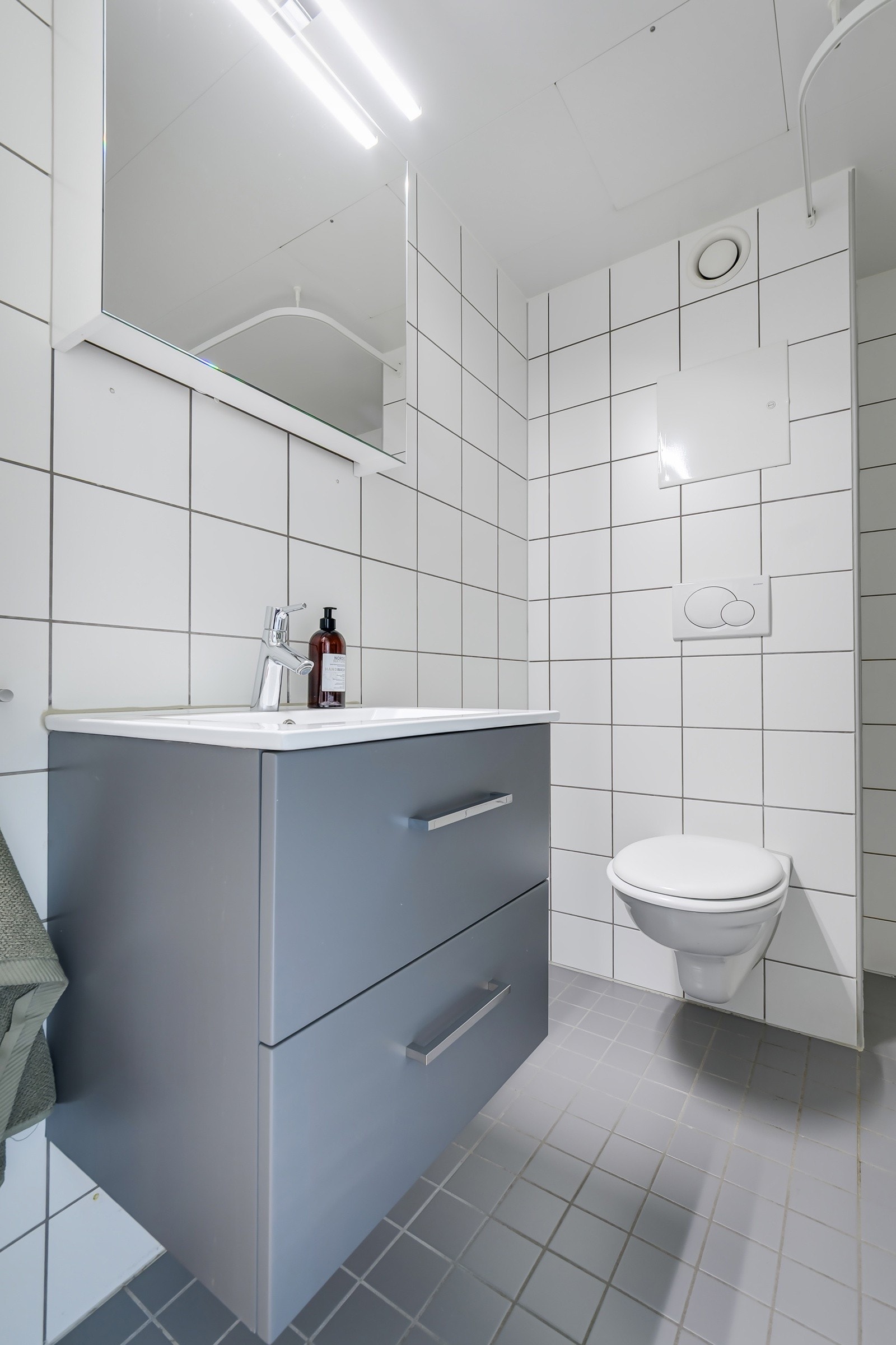 Tidløs baderomsinnredning med nyere servantskap (nytt i 2020) og speilskap med belysning over. Baderommet er også utstyrt med åpent dusjhjørne samt vegghengt toalett. Galleribilde