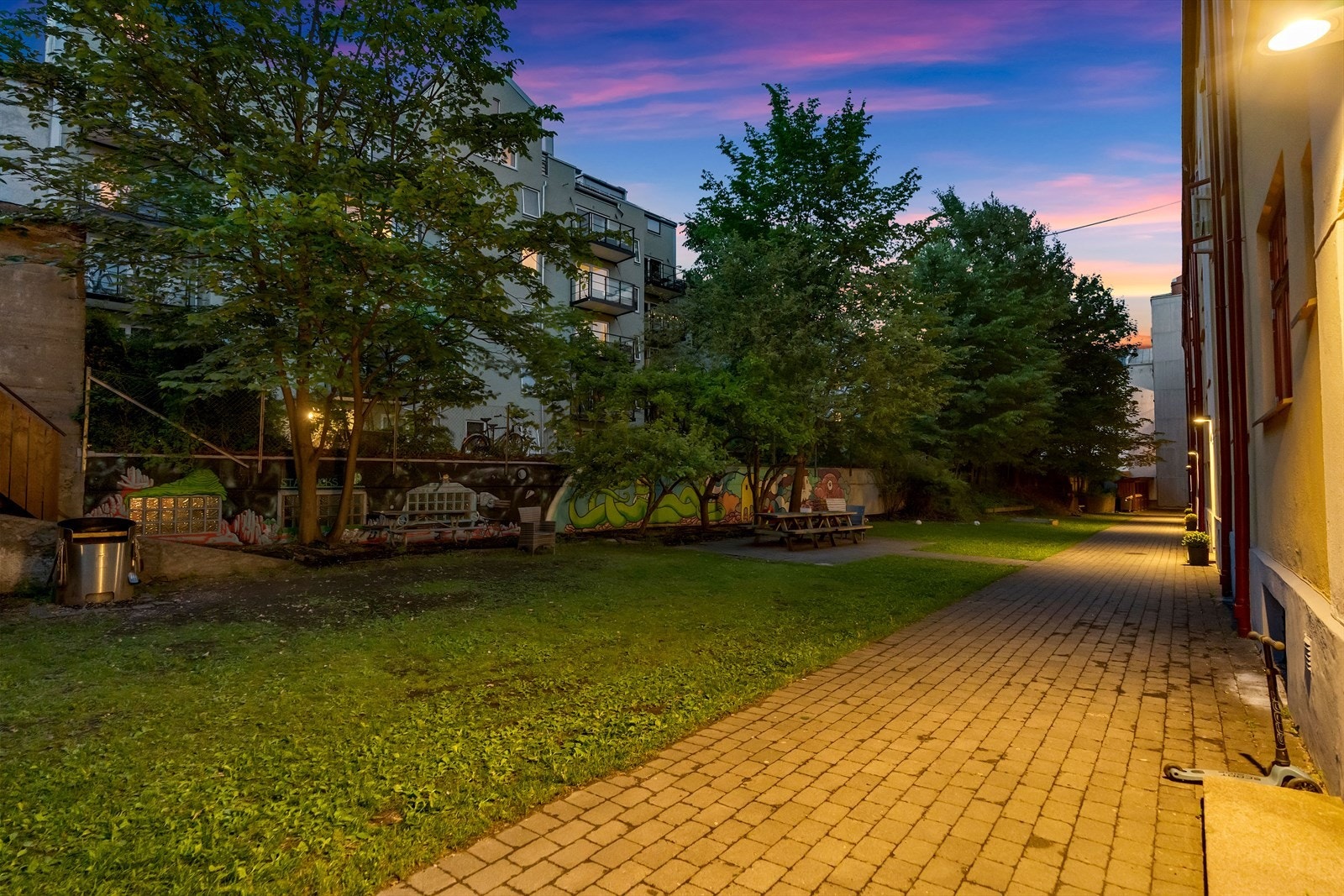 Trivelig og frodig bakgård med sittegrupper og sykkelparkering. Galleribilde