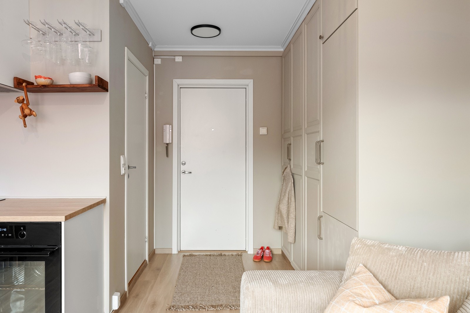 Innbydende entré med stort plassbygget garderobeskap. Det er kjøleskap/fryser og opplegg for mikro i det ene skapet Galleribilde