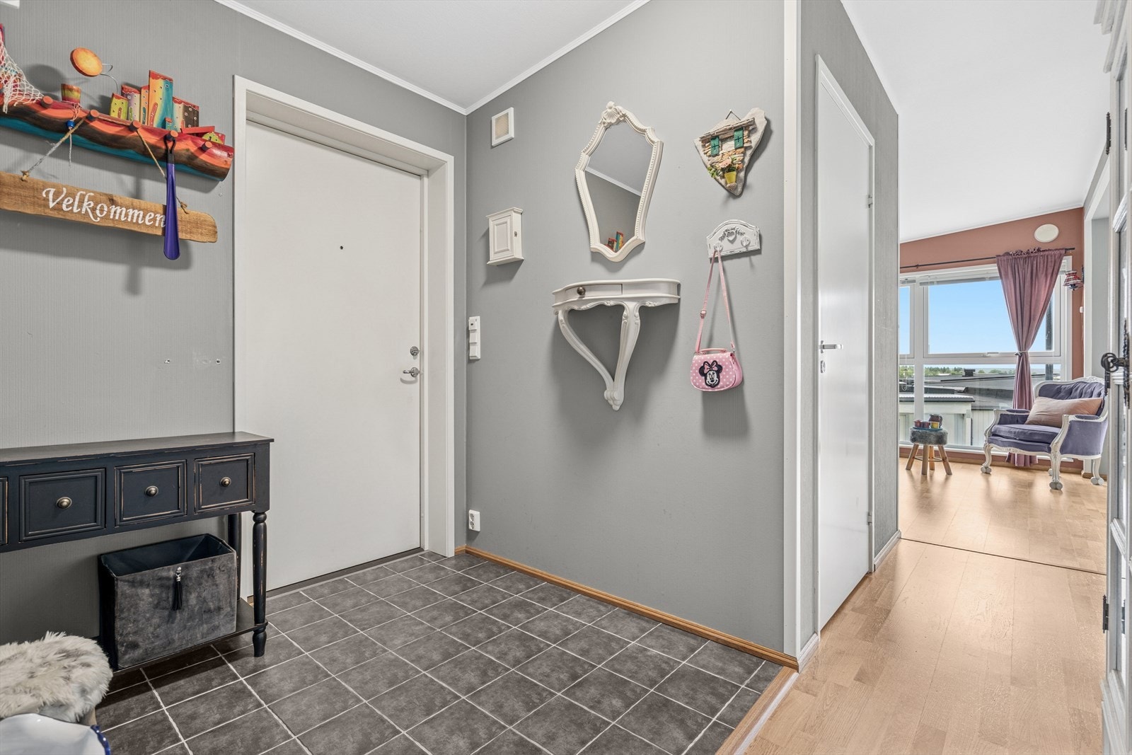 Man ønskes velkommen i en flislagt entré med plass til å henge fra seg yttertøy. Galleribilde