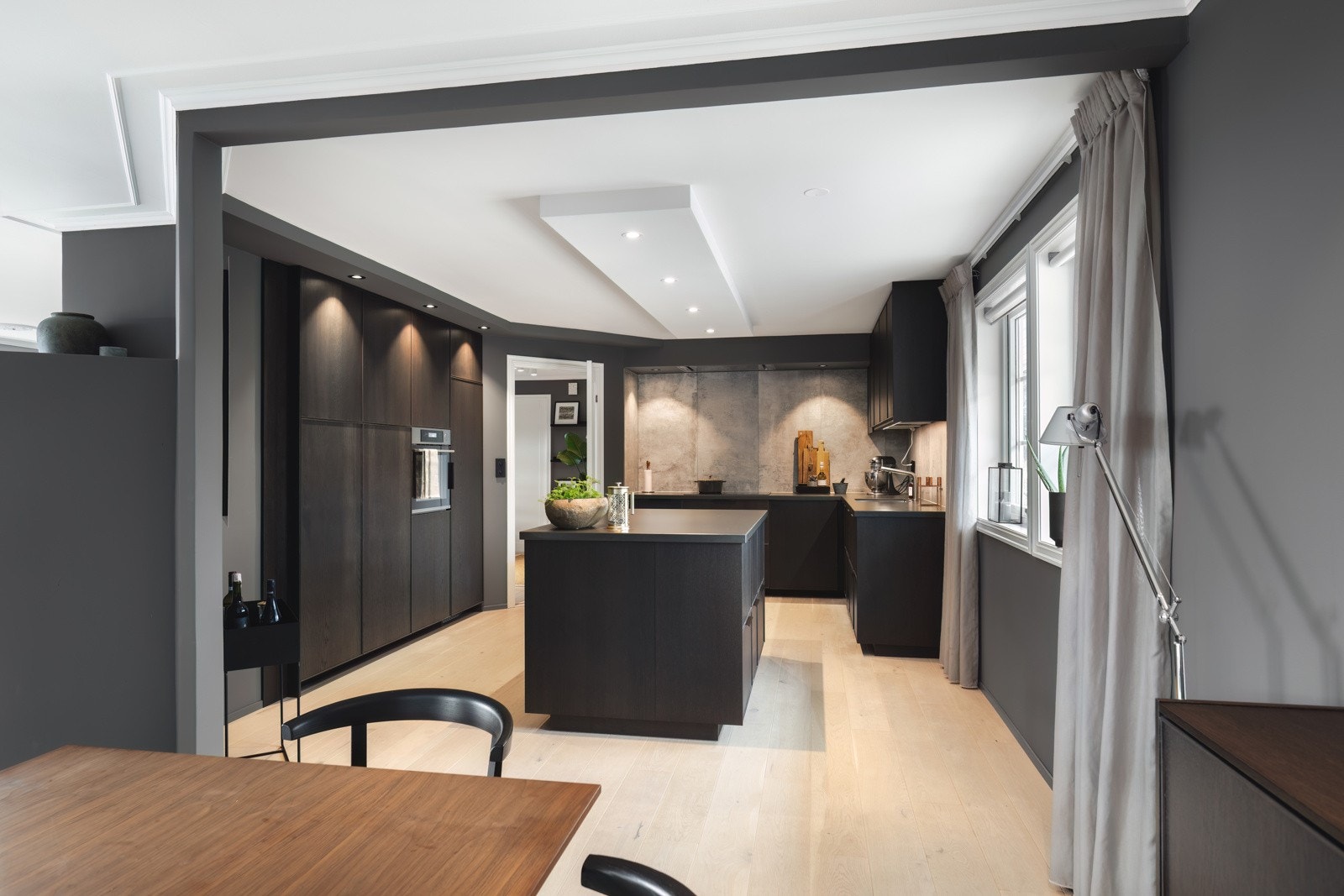 Kjøkken i moderne design. Innredning med glatte fronter med tre struktur. Benkeplate i silestone. Galleribilde