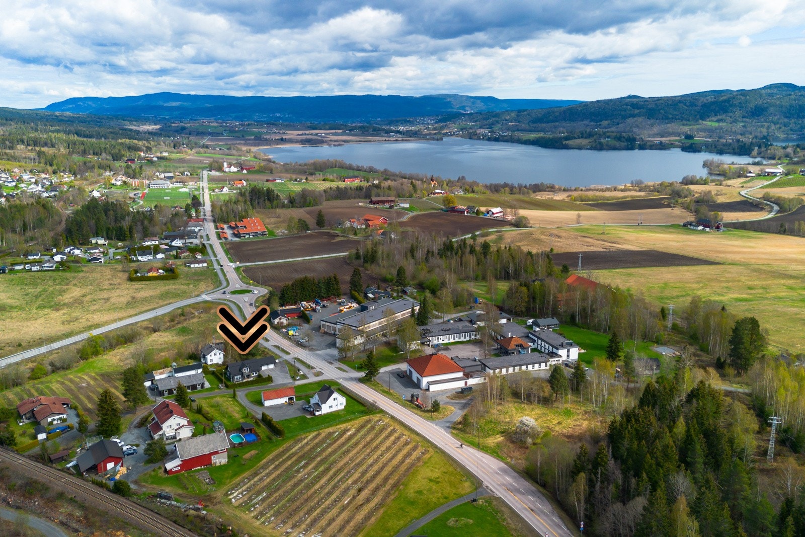 Eiendommen er belligende i et boligområde med nærhet til innsjø, åser i bakgrunnen og landlige omgivelser. Galleribilde