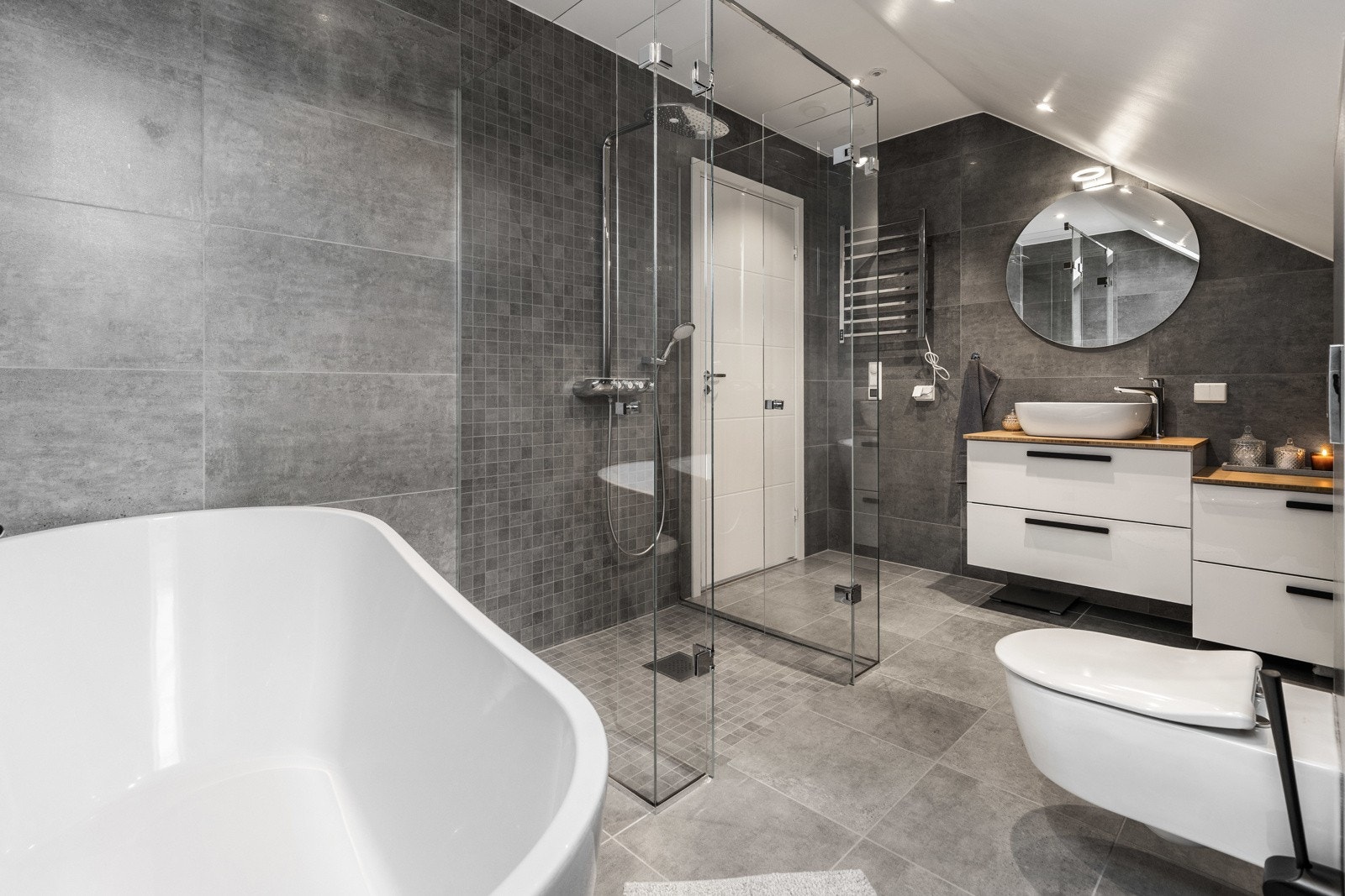 Moderne bad med frittstående badekar, dusjhjørne og hvit baderomsinnredning. Galleribilde