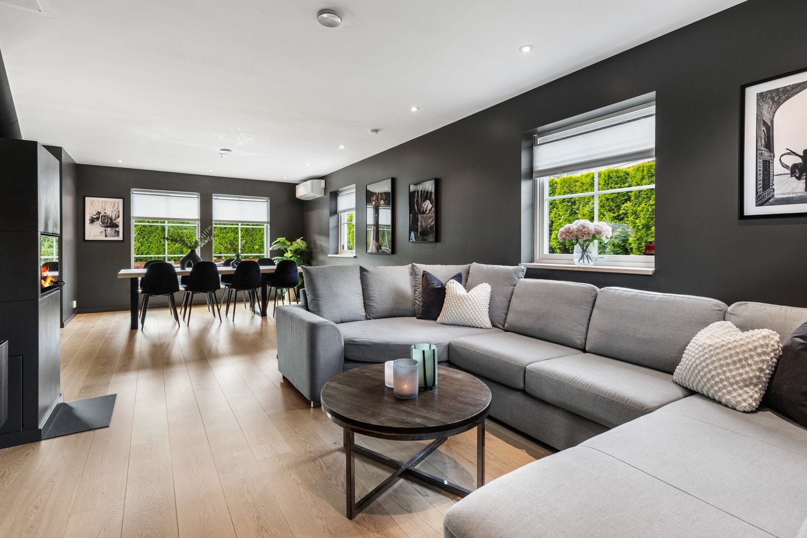 Lys og romslig stue med store vinduer og åpen planløsning mot spisestue. Galleribilde