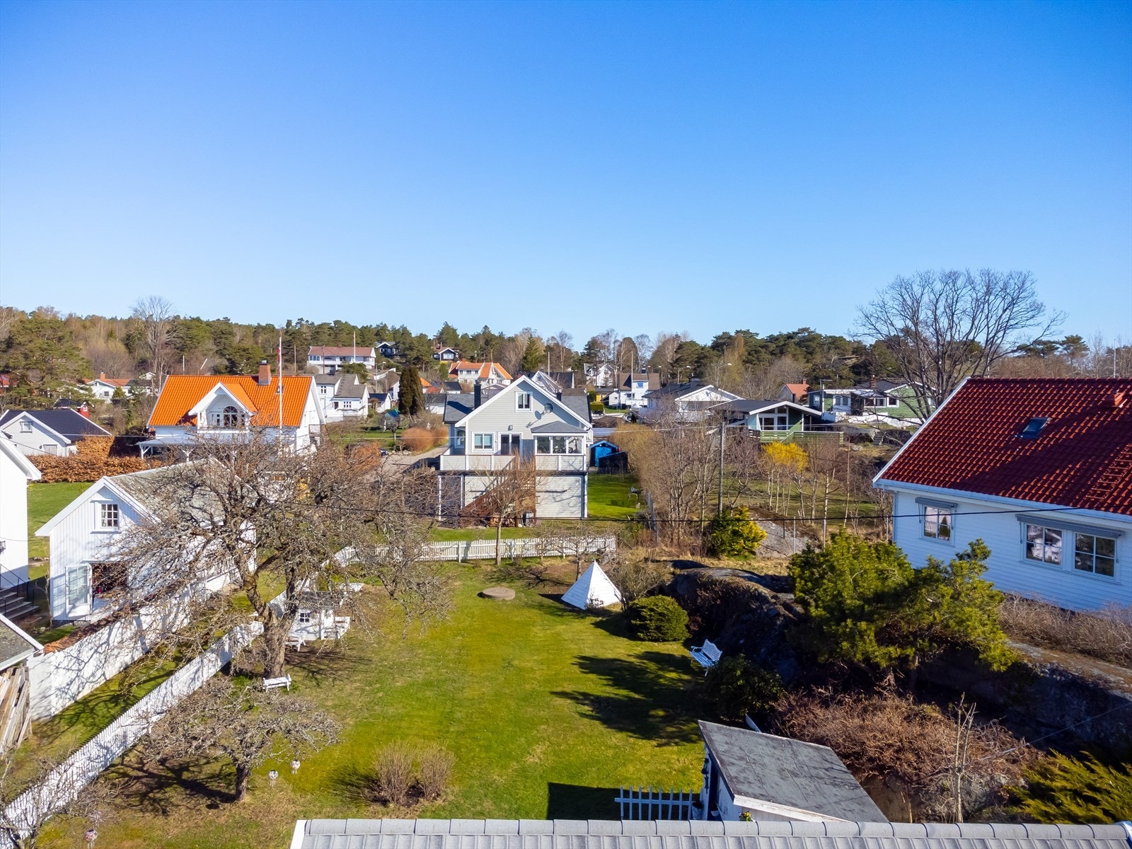 Baksiden av boligen byr på en romslig og idyllisk hage med grønne områder og plass til både lek og avslapning. Her kan familien nyte rolige stunder i fredelige omgivelser, med god plass til utemøbler og sosiale aktiviteter. Galleribilde
